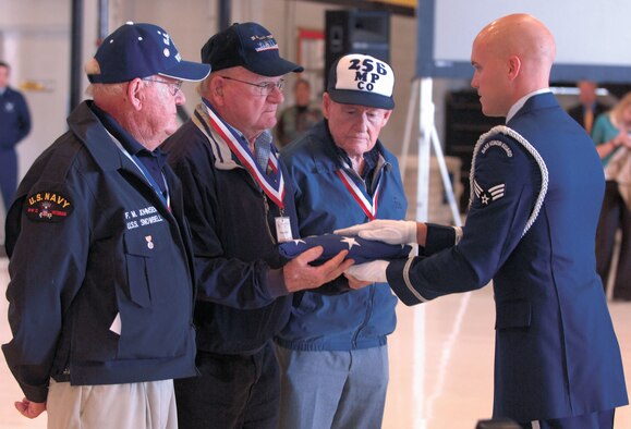 Three brothers, Mr. Fred, Woody and Norton Johnson, are presented the flag from a member of the Hill Air Force Base Honor Guard to carry to the Washington Monument for a ceremony there Sept. 15.