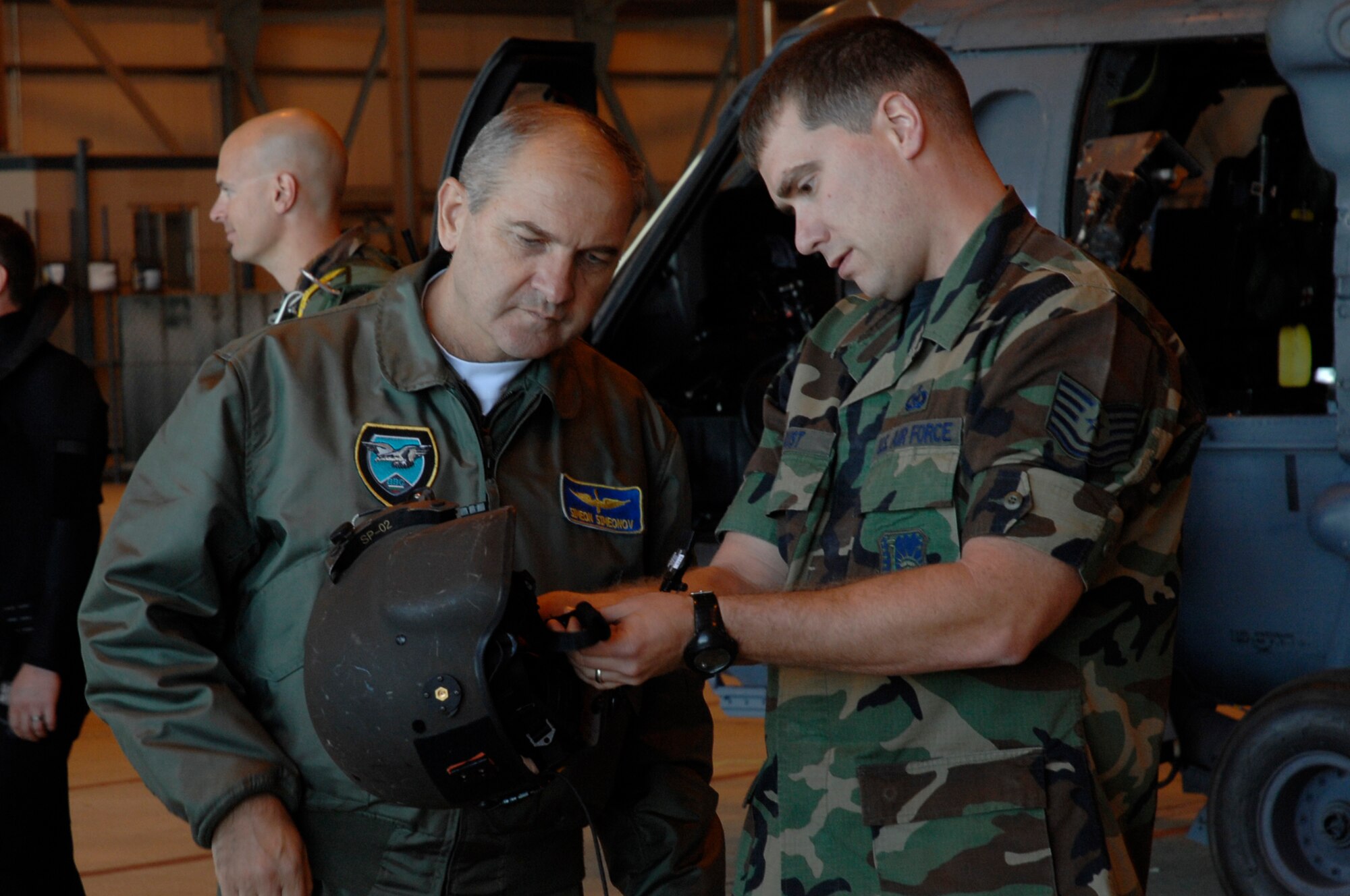 Bulgarian Lt. Gen. Simeon Simeonov, Chief of Bulgarian Air Force Headquarters, receives a briefing from 48th Operations Support Squadron Tech. Sgt. Joe Rust on the basic care and functions of the flight helmet before boarding the 56th Rescue Squadron HH 60 aircraft on Sept. 18. (U.S. Air Force photo by Airman 1st Class Erika Brooke)