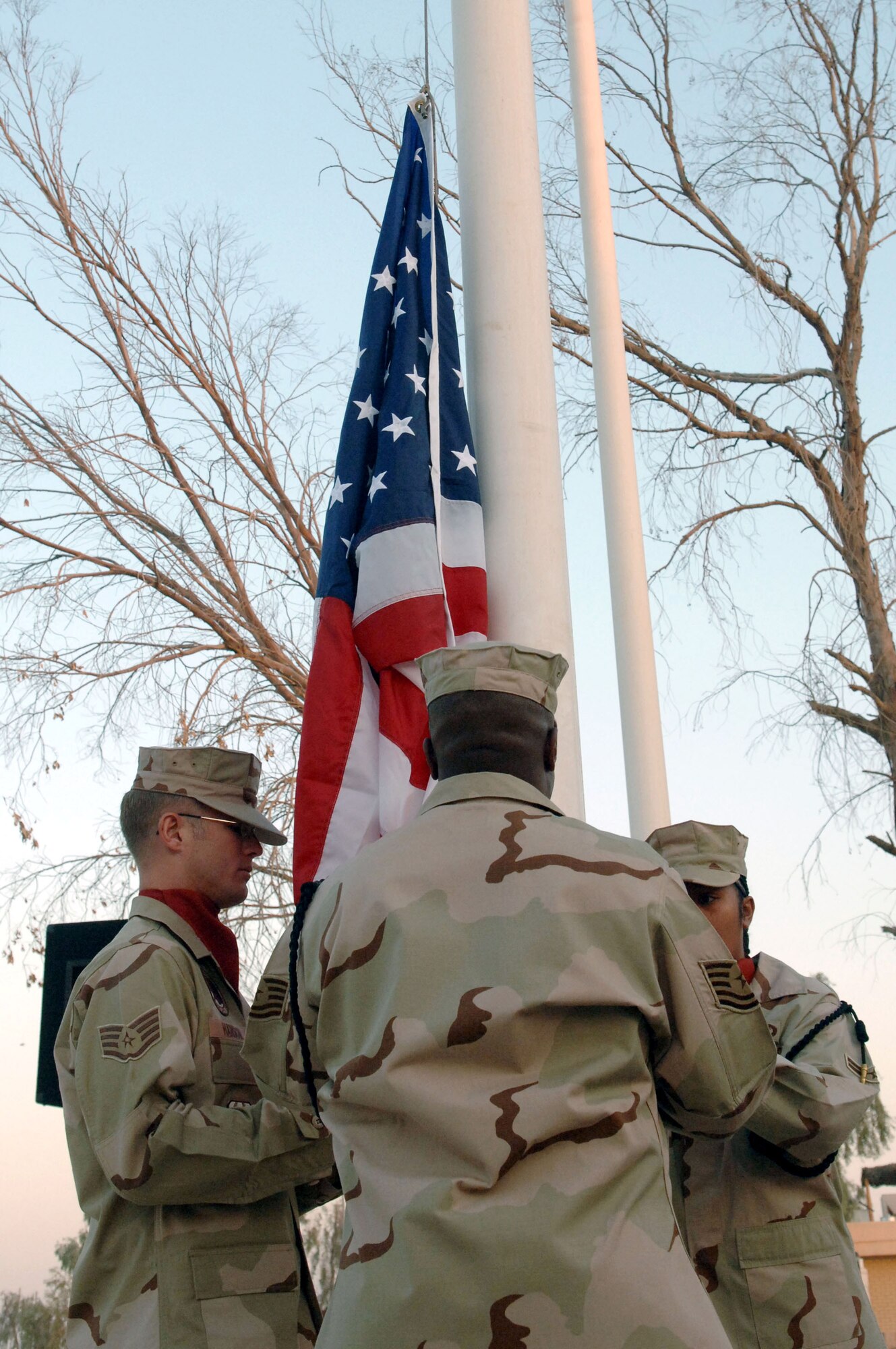 Staff Sgt. Joshua Hanson, Tech. Sgt. Sean Hannah and Senior Airman Joyleen Roberts raise the American flag during a reveille ceremony Sept. 18 at Balad Air Base, Iraq. Members of the 332nd AEW, the most forward-deployed Air Force wing in Iraq, held the ceremony in observance of the Air Force's 60th birthday. The wing draws its heritage from the famed 332nd Fighter Group, led by the Tuskegee Airmen of World War II, and carries this spirit in operations here. Sergeants Hanson, Hannah and Airman Hannah are from the 332nd AEW Honor Guard. (U.S. Air Force photo/Staff Sgt. Joshua Garcia) 
