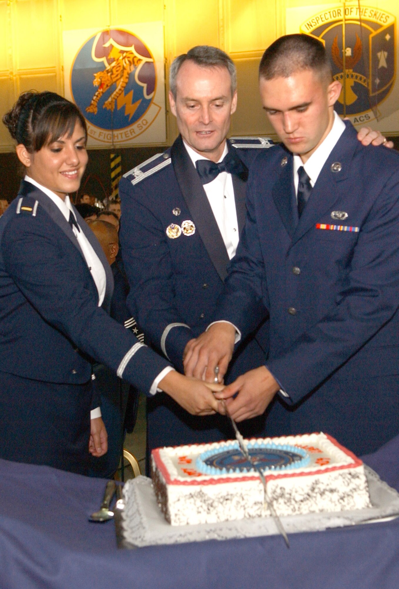 SPANGDAHLEM AIR BASE, Germany -- Col. Darryl Roberson, 52nd Fighter Wing commander, is assisted in cutting the Air Force Ball cake by 2nd Lt. Ingrid Muniz, 52nd Civil Engineer Squadron, and Airman Basic Nick Smith, 52nd Logistics Readiness Squadron, Sept. 15. (U.S. Air Force photo/Airman 1st Class Allen Pollard)