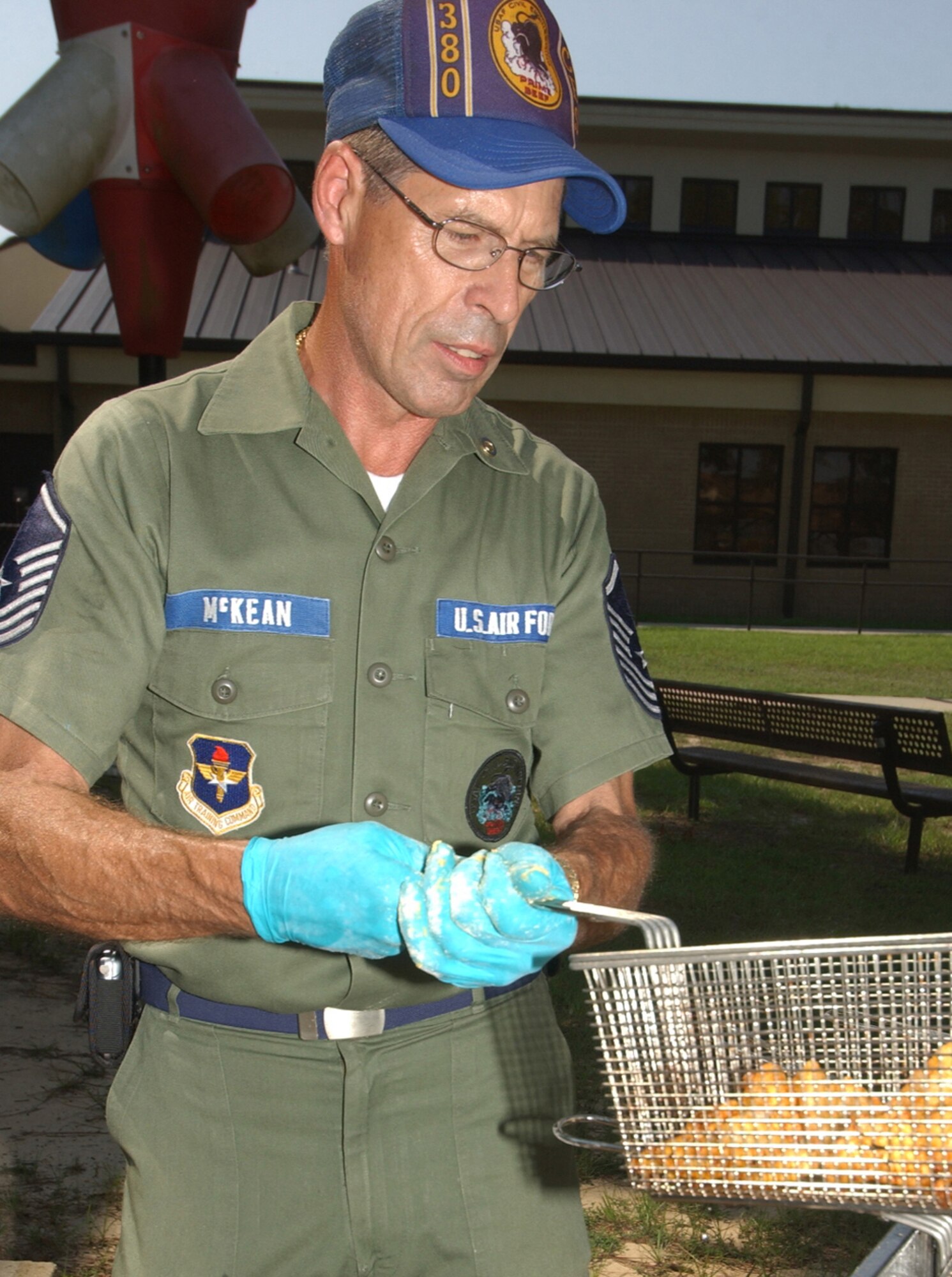 Retired Senior Master Sgt. Larry McKean fries fish in a vintage Air Force uniform outside the youth center Monday for the Retiree Appreciation Day picnic.  He’s now a civilian employee of the 81st Civil Engineer Squadron and president of The Retired Enlisted Association.  (U.S. Air Force photo by Kemberly Groue)