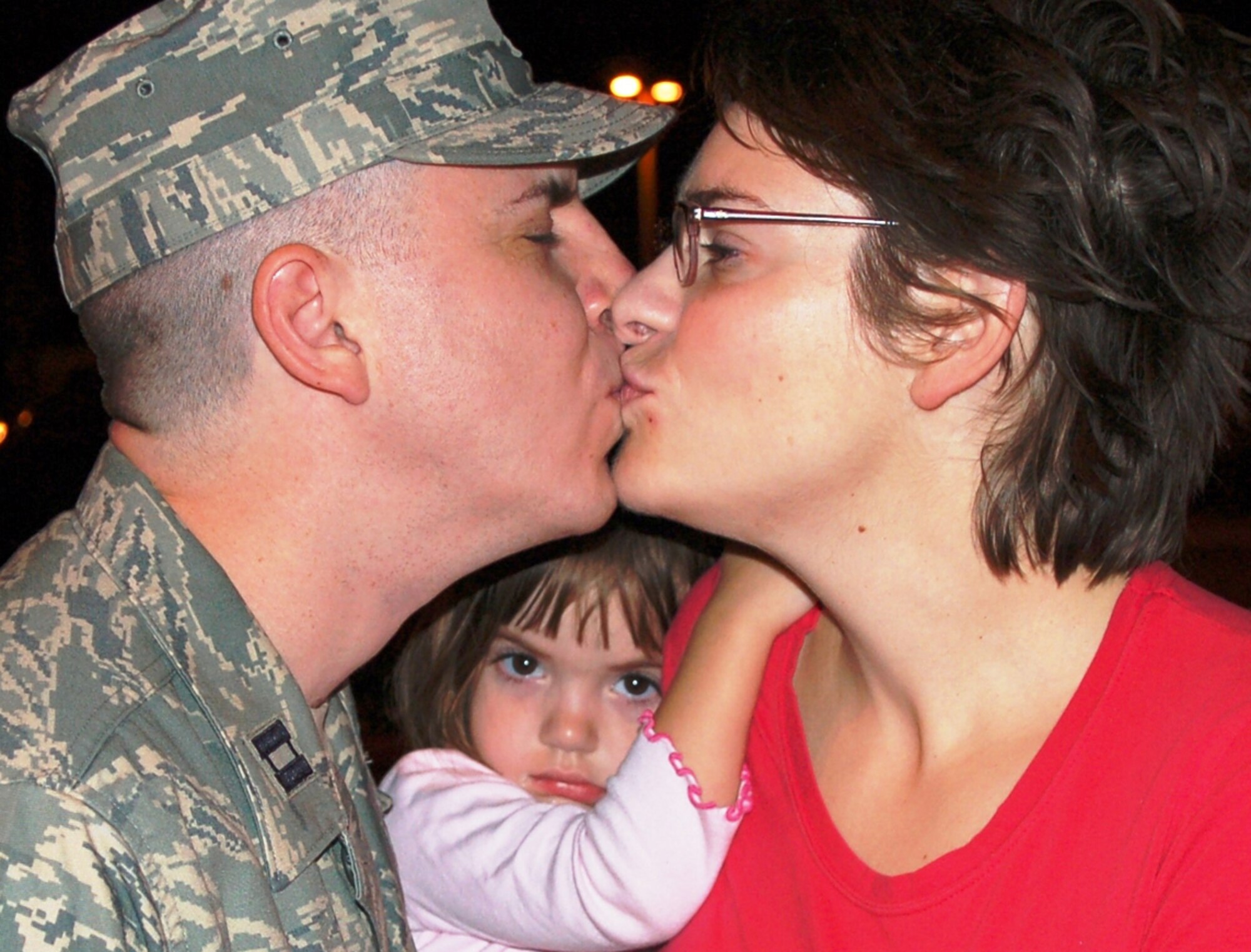 Capt. William Clark kisses wife Shelley as 3-year-old daughter Tallulah waits her turn.  He and nine other members of the 81st Surgical Operations Squadron departed Keesler Sept. 12 to begin a 120-day deployment to South-west Asia to care for U.S. and coalition forces and other patients.  (U.S. Air Force photo by Steve Pivnick)