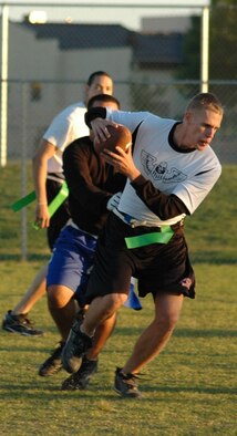 Matt Lintker, 490th Missile Squadron, squeezes by the defense during an intramural flag football game against the 341st Maintenance Operation Squadron's team Sept. 13. The 341st MOS team won 20-14. (U.S. Air Force photo/Airman 1st Class Emerald Ralston)