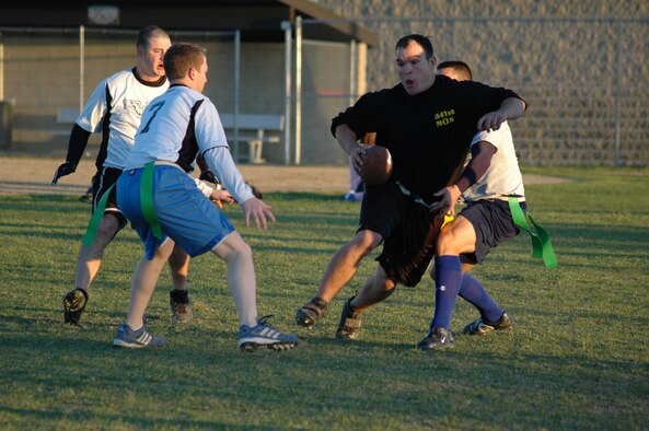 Jarden Thorton, 341st Missile Maintenance Squadron, manuevers around members of the 490th Missile Squadron's football team in a game Sept. 13. Thorton played for the  341st Maintenance Operations Squadron team which took the game 20-14. (U.S. Air Force photo/Airman 1st Class Emerald Ralston)