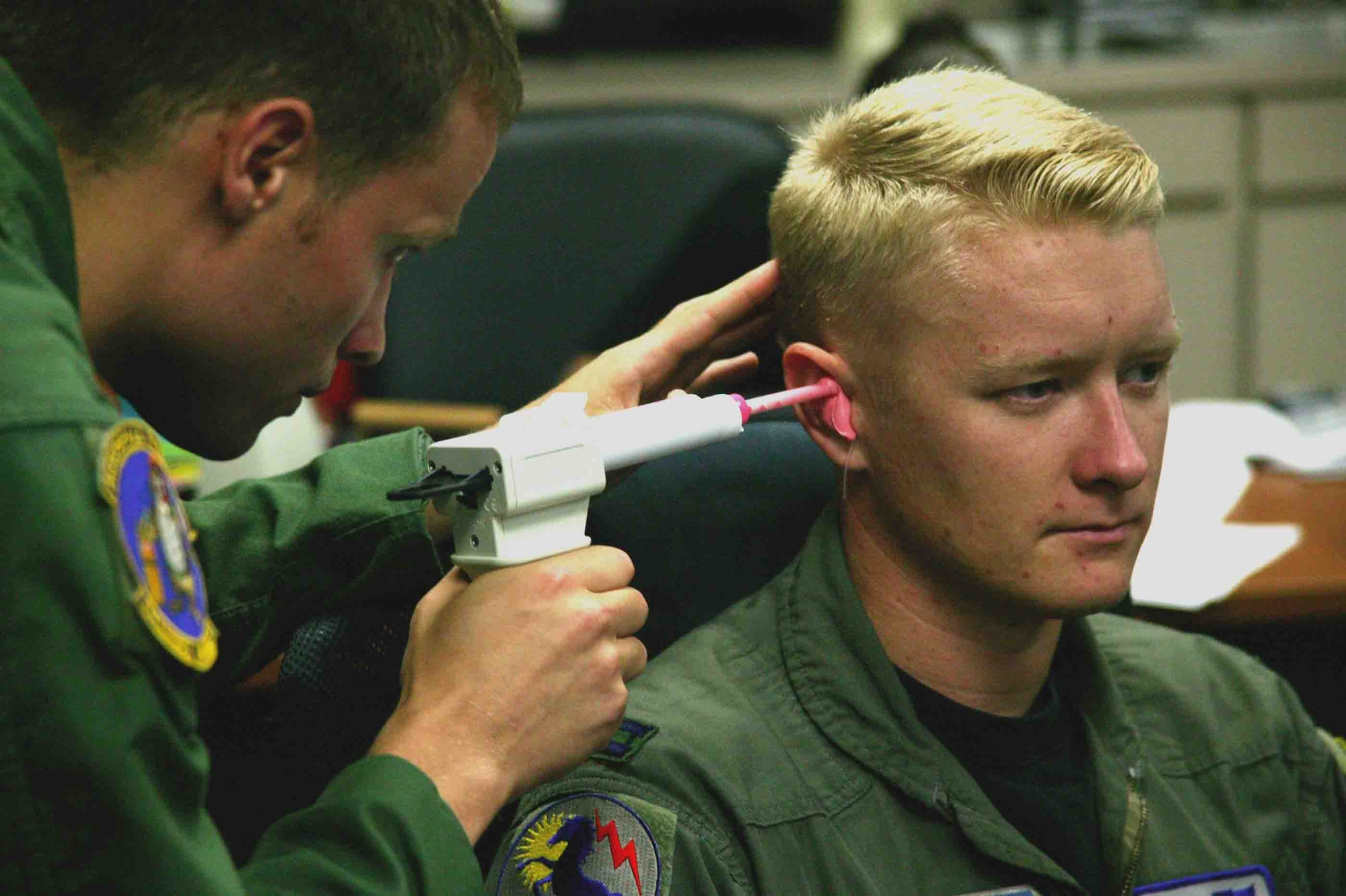 SHAW AIR FORCE BASE, S.C. -- Second Lt. Chris Reichlen (left), 20th Aerospace Medicine Squadron aerospace physiologist, inserts silicone based mixture into the ear of Capt. Jerad Hand, 79th Fighter Squadron F-16CJ pilot, to make an inner-ear mold for the Attenuating Custom Communications Earpiece System Sept. 14. The ACCES device will significantly reduce surrounding ambient noise that pilots hear in the cockpit and increase the efficiency of radio communications. (U.S. Air Force photo/Senior Airman John Gordinier)