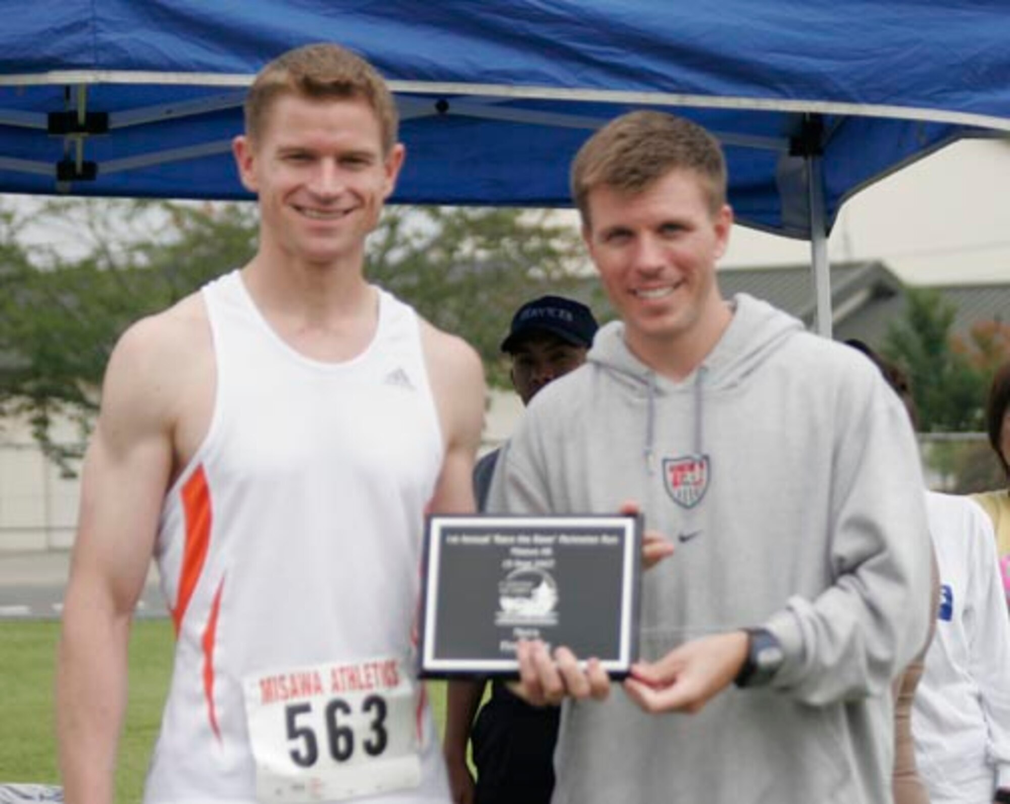 MISAWA AIR BASE, Japan -- Jason Vandenberg (right), 35th Services Squadron fitness director, presents Mike French (left) with a plaque after the first annual "Race the Base" perimeter run here Sept. 15. Mr. French was the top male finisher with a 8.5-mile time of 49.04. Kristoffer Chacon was the second male finisher with a time of 50.39. The third male finisher was Ebena Keise with a time of 50.54. (U.S. Air Force photo)