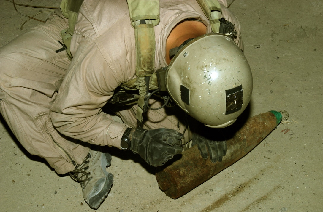 A Marine with an explosive ordnance disposal team inspects an artillery round that was found during patrols through a village in Karmah, Iraq, Sept. 22. The artillery round was wired to be used as an improvised explosive device and was found in a recently abandoned house in the village among other bomb making materials. This is one of the many caches the Marines of Company L, 3rd Battalion, 3rd Marine Regiment, have found since arriving into the area.