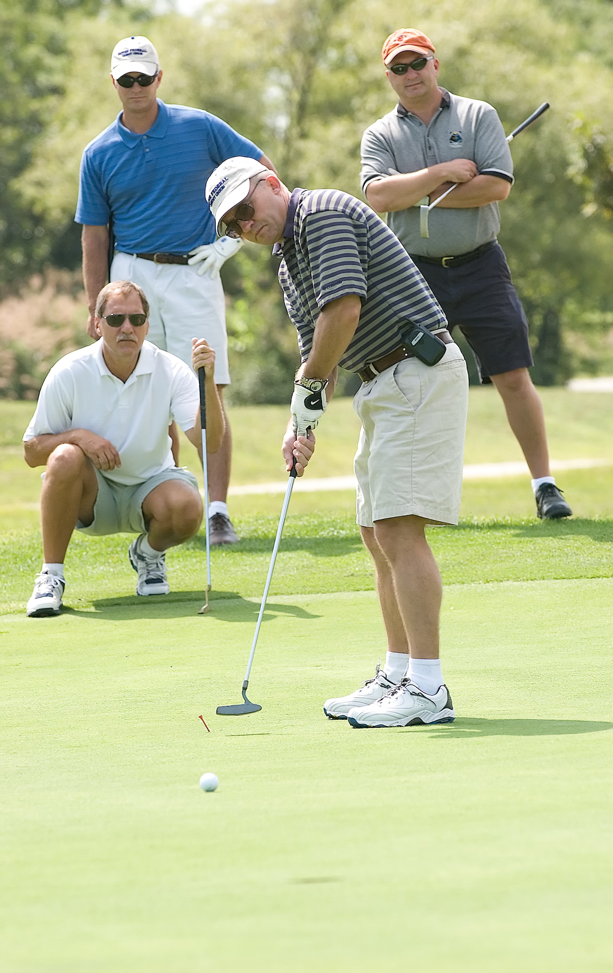 Col. Merrill Alligood, 436th Operations Group commander, putts during the 436th Airlift Wing Bluesuiters Golf Tournament at Eagle Creek Golf Course Sept. 13. As teammates Bobby Naftzinger, Dover Federal Credit Union, Chief Master Sgt. Rick Ross, 436th OG superintendent, and Dave Clendaniel, 436th OG honorary commander, look on.  The team of Tech. Sgt. Steve Dirksen, Col. Vic Sowers, Dave Clapp and Senior Airman Chris Brondyke claimed first place honors in the annual event, where community members and Dover Team members come together for a day of fun and camaraderie. (U.S. Air Force photo/Jason Minto)