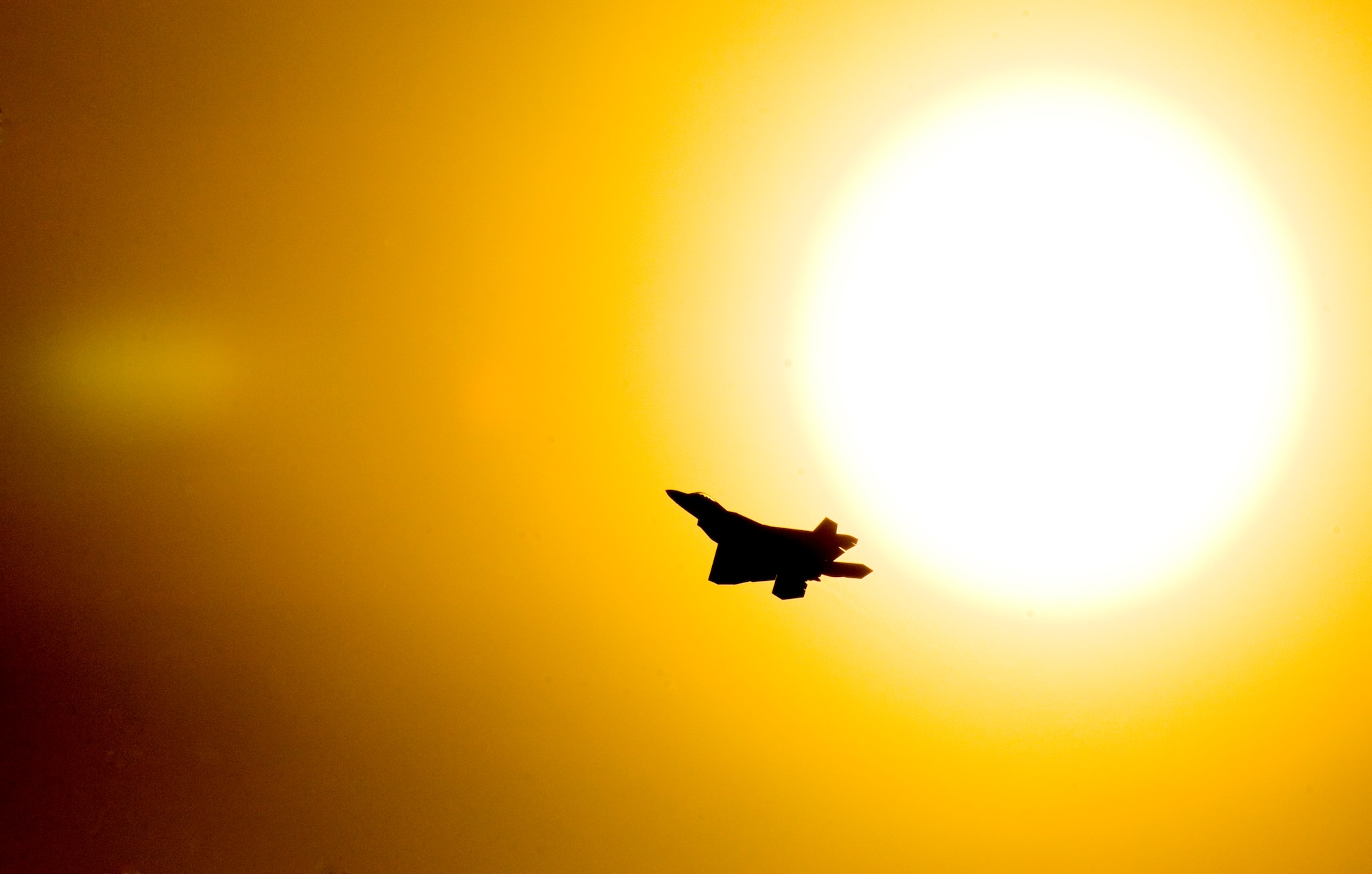 ELMENDORF AIR FORCE BASE, Alaska -- An F-22 A Raptor passes by a slowly setting Alaskan sun, while practicing touch and goes on the flightline here. (U.S. Air Force photo by Senior Airman Garrett Hothan)