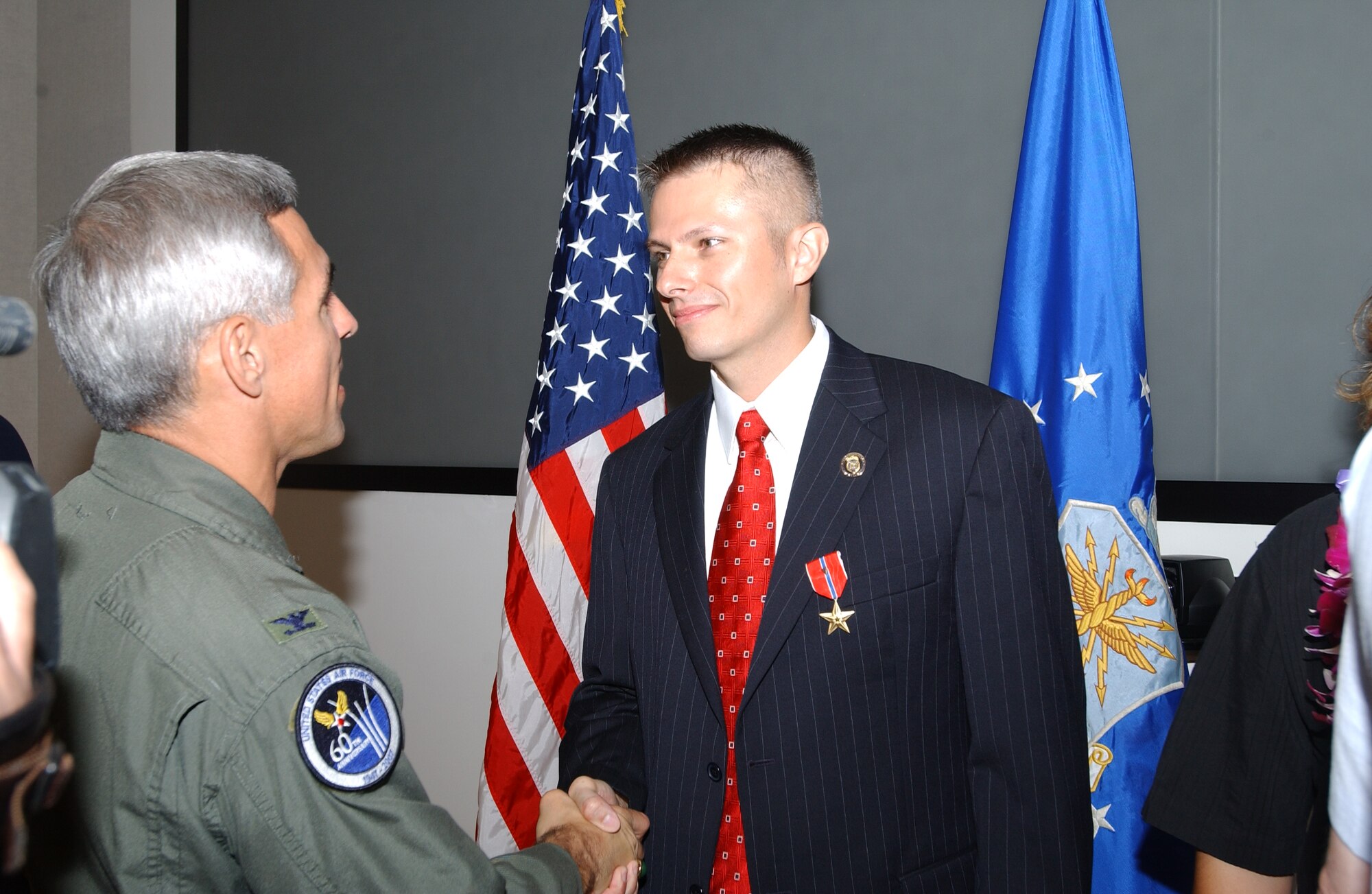 Col. J.J. Torres, 15th Airlift Wing commander, thanks Special Agent Gregory Carmack for his service, after the Bronze Star presentation ceremony.
