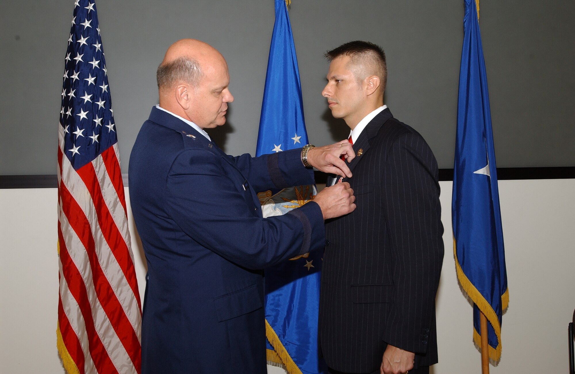 Brig. Gen. Dana Simmons, Air Force Office of Special Investigations commander, presents the  Bronze star with Valor to Special Agent  Gregory A. Carmack for his heroism.