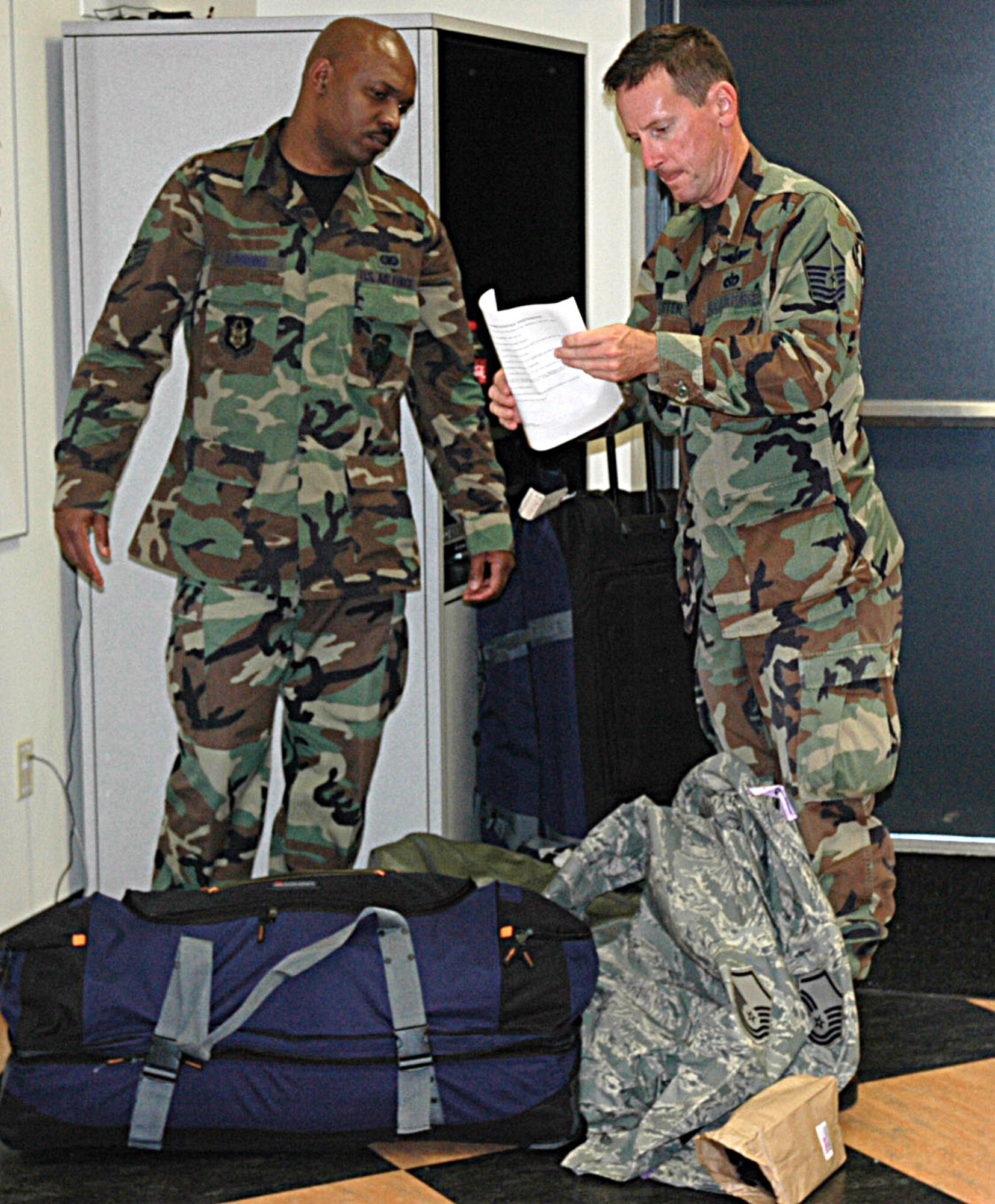Reservists Staff Sgt. Demond Loggins, left, and Master Sgt. Chris Webster, 446th Civil Engineer Squadron, review their departure checklist Sept. 10 as they prepare to head out to Wisconsin, and then Iraq.  Fourteen Airmen from the 446th Airlift Wing will be joining forces with the 819th RED HORSE Squadron, Malmstrom AFB, Mont., for a six-month deployment. (U.S. Air Force photo/Sandra Pishner)