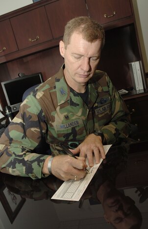Col. John "Red" Millander, 437th Airlift Wing commander and 2007 Coastal Carolina Combined Federal Campaign chairman, fills out a plede card for donating to CFC.  CFC kicked off on base Wednesday and will last through Oct. 31. (U.S. Air Force photo/Airman Melissa White)