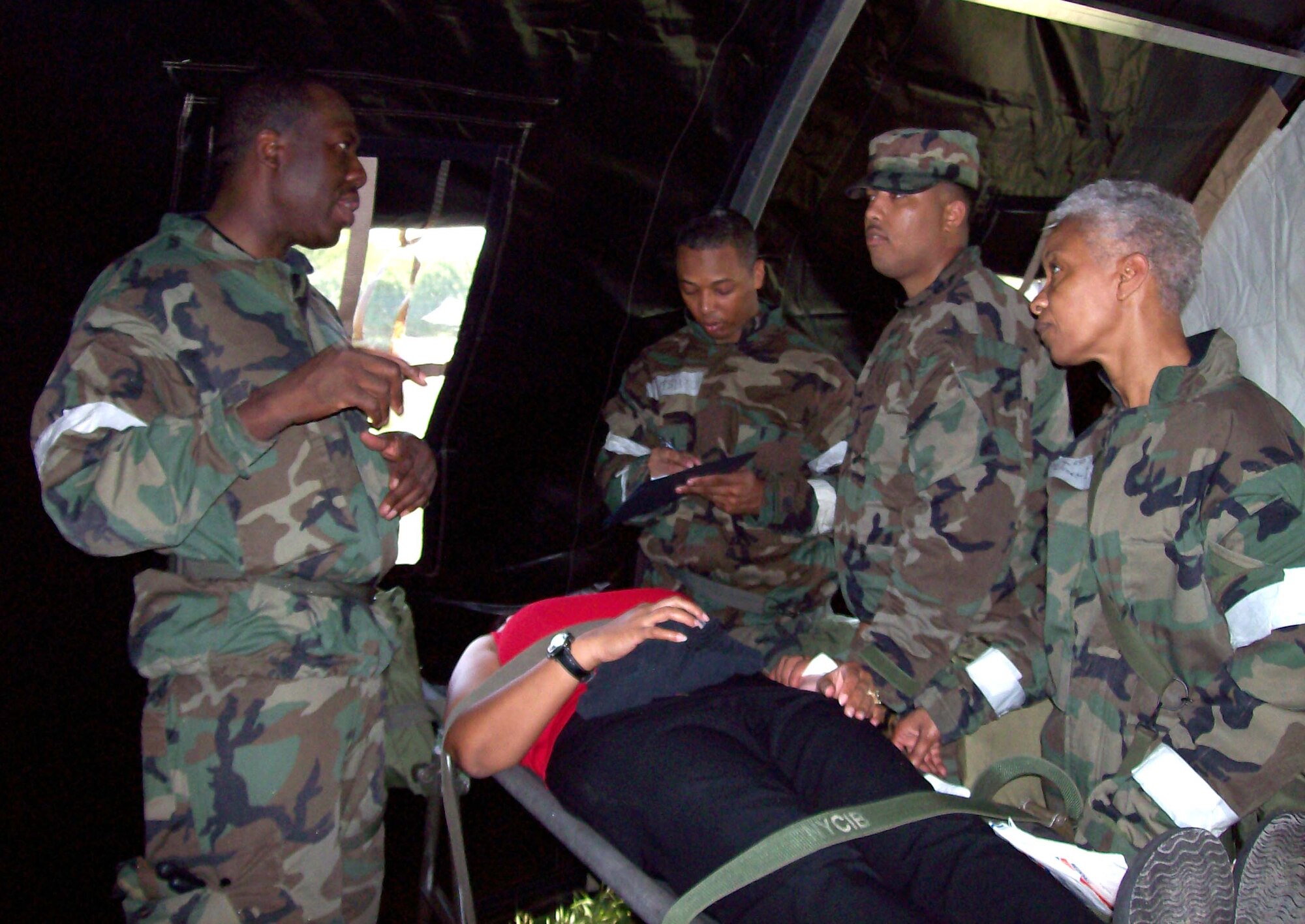 ANDREWS AIR FORCE BASE, Md. -- Lt. Col. Jimmie Drummond discusses patient treatment with Senior Airman Dustun Ashton, Senior Airman Komonty Harvey, and Senior Master Sgt. Jennifer Jones-Everett. Colonel Drummond is a flight surgeon, Airman Ashton is an aeromedical technician, and Sergeant Jones-Everett is a medical materiel craftsman with the 459th Aeromedical Staging Squadron. (U.S. Air Force photo/Capt. Sheila Arrington)
