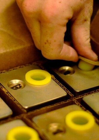 Airman 1st Class David Collins, 437th Maintenance Squadron munitions crew member places caps on expired flair igniters at the Charleston AFB, S.C. munitions bay on Sept. 11.(U.S. Air Force photo/Airman 1st Class Nicholas Pilch) 
