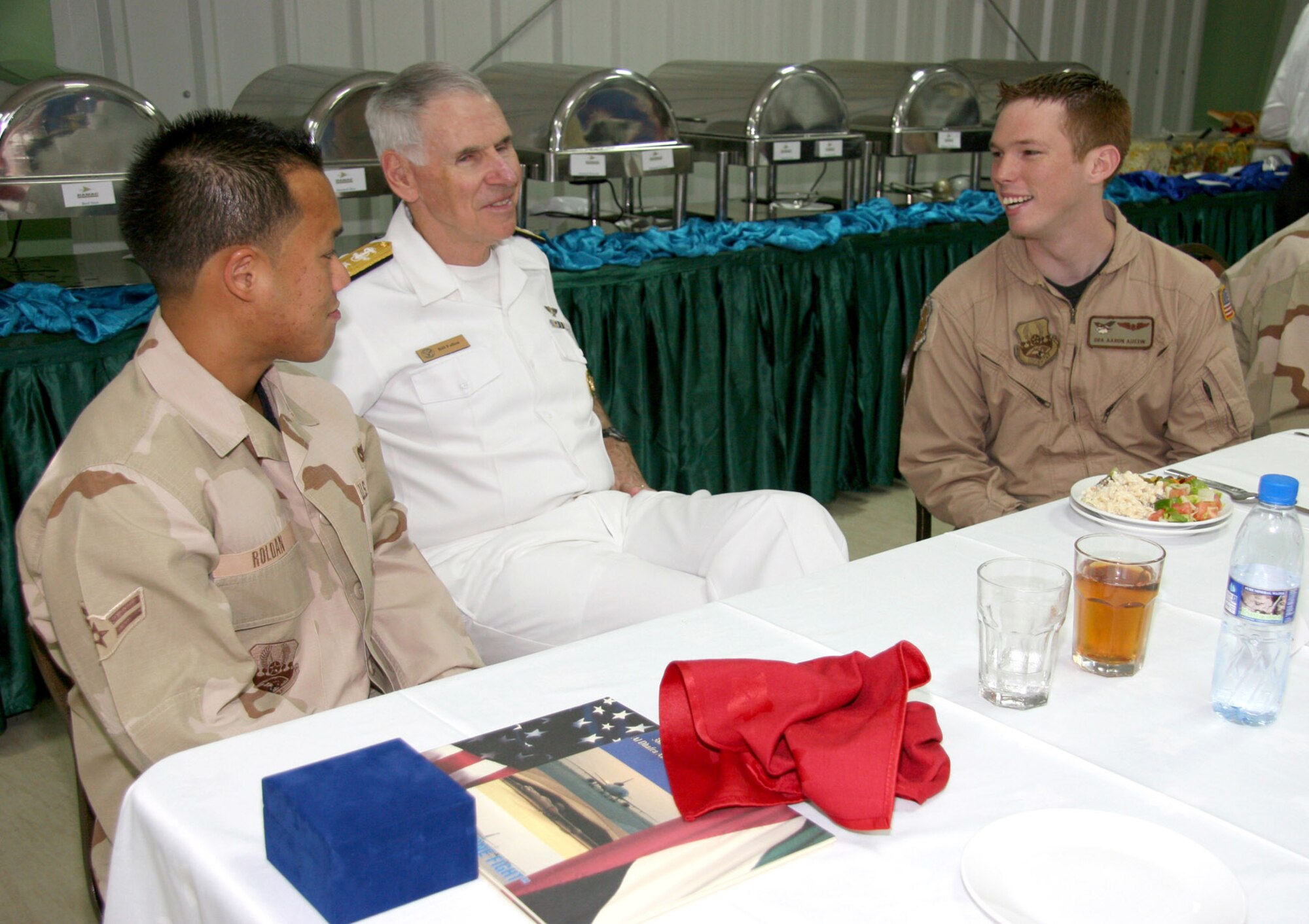 Adm. William J. Fallon talks to Airman 1st Class Alfred Roldan (left) and Senior Airman Aaron Austin during a luncheon Sept. 17 at the 380th Air Expeditionary Wing in Southwest Asia. Admiral Fallon is the U.S. Central Command commander. Airman Roldan is with the 380th Expeditionary Civil Engineer Squadron and Airman Austin is with the 908th Expeditionary Air Refueling Squadron. (U.S. Air Force photo/Master Sgt. Ruby Zarzyczny)