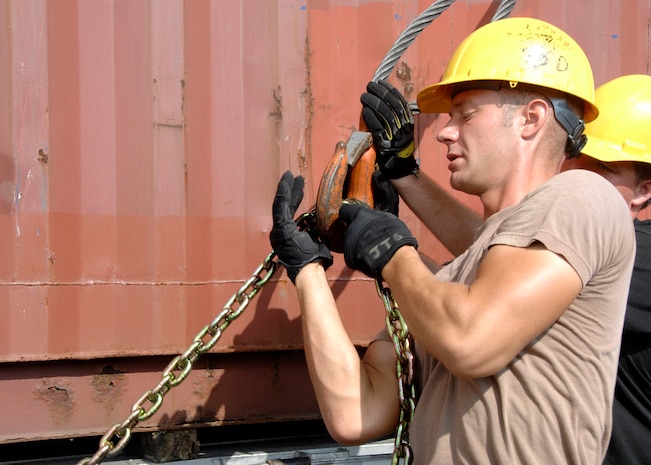 Airman 1st Class Jason Golden, 437th Aerial Port Squadron air transportation specialist and cargo processor, attaches a chain to a crane cable to remove a 40-foot container from a flatbed truck Sept. 13 at the aerial port. (U.S. Air Force photo/Airman 1st Class Katie Gieratz)