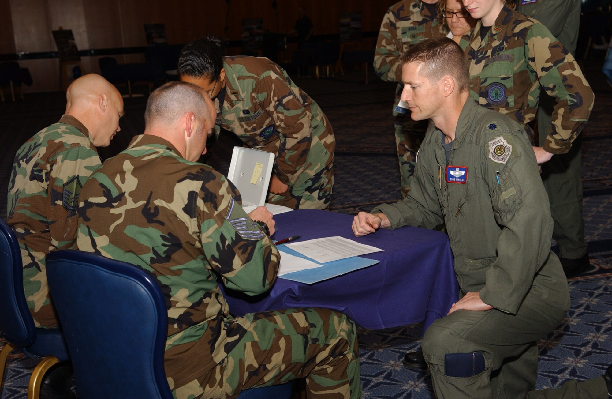 SPANGDAHLEM AIR BASE, Germany – Lt. Col. Douglas Nikolai, 52nd Fighter Wing director of staff, pays for his Air Force 60th Anniversary coin during the Air Force Birthday Bash at Club Eifel Sept. 18. The numbered anniversary coins were auctioned off by the Spangdahlem Air Base Air Force Ball planning committee. (U.S. Air Force photo/Airman 1st Class Allen Pollard) 