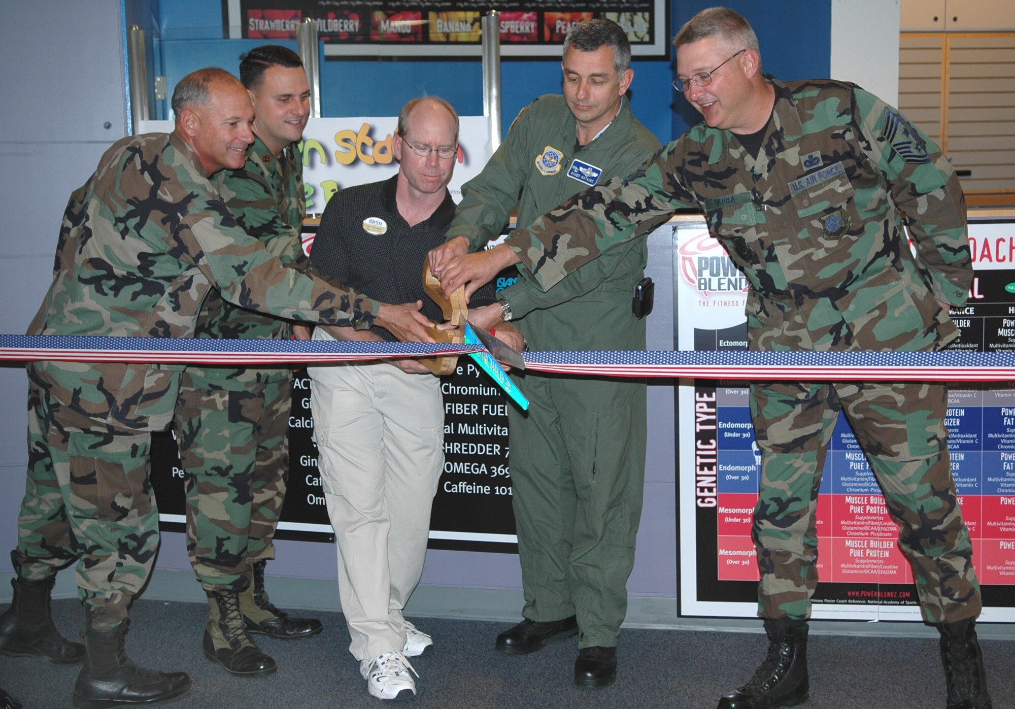 FAIRCHILD AIR FORCE BASE, Wash. – Col. Van Fuller, 92nd Mission Support Group commander; Maj. David Ellison, 92nd Services Squadron commander; John Gahagan, fitness center athletic director; Col. Roger Watkins, 92nd Air Refueling Wing vice commander; and Chief Master Sgt. Paul Sikora, 92nd Air Refueling Wing command chief, use the wing scissors for the ribbon cutting at the grand opening of the fitness center’s new juice bar. (U.S. Air Force photo / Airman 1st Class Kali L. Gradishar)
