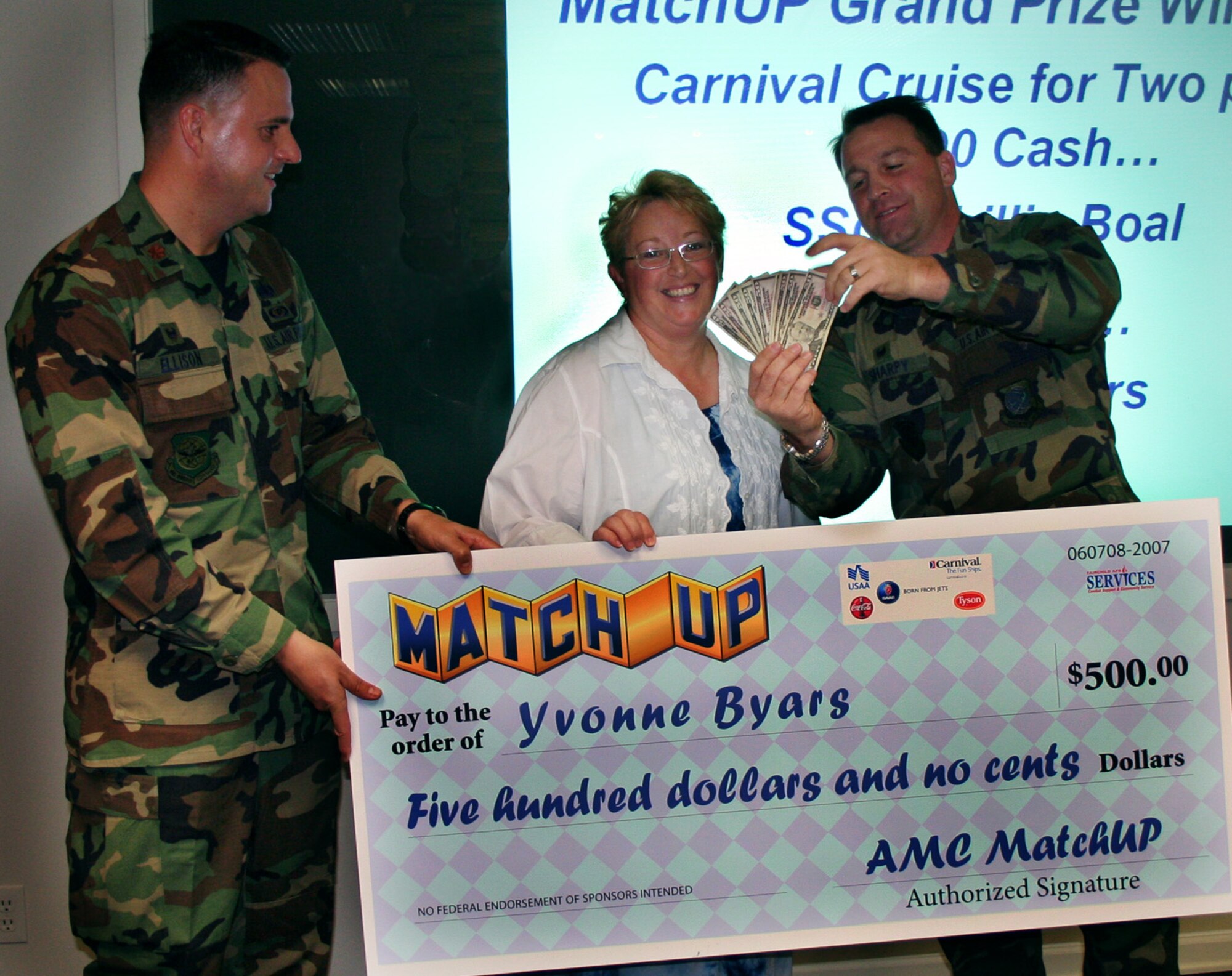 FAIRCHILD AIR FORCE BASE, Wash. – Yvonne Byars receives her $500 MatchUp prize from Maj. David Ellison (left), 92nd Services Squadron commander, and Col. Thomas Sharpy, 92nd Air Refueling Wing commander. Fairchild came in at third place in the Air Mobility Command game, with participation rates at 105 percent. (U.S. Air Force photo/Corrine Brown) 
