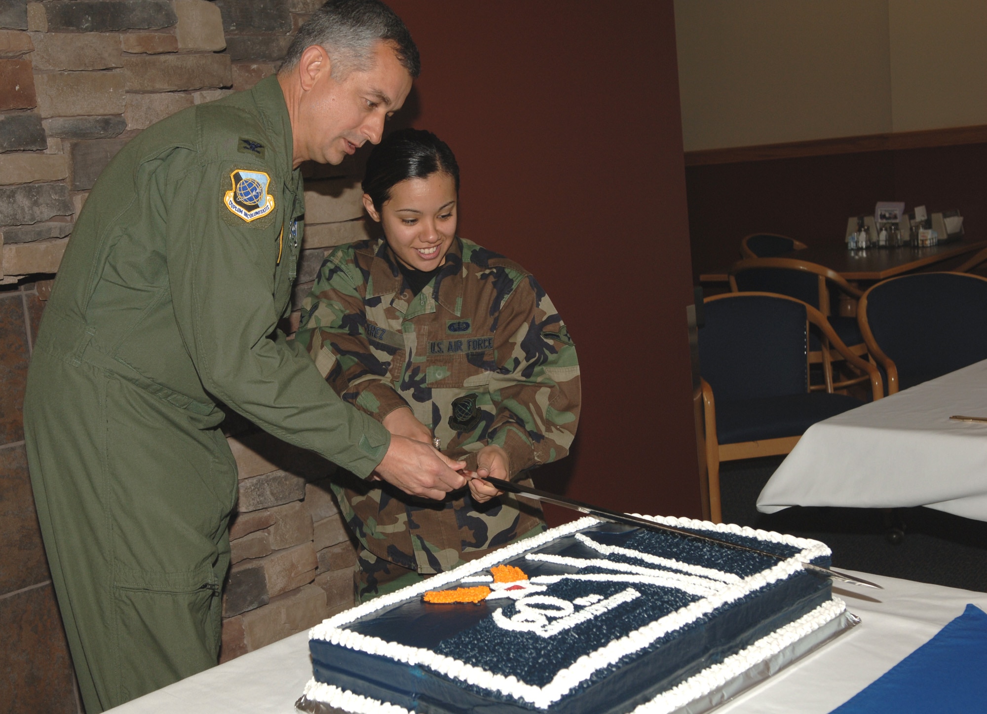 FAIRCHILD AIR FORCE BASE, Wash. -- During a celebration at Warrior Dining Facility commemorating the 60th Anniversary of the Air Force, Col. Roger Watkins, 92nd Air Refueling Wing commander, and Airman Amy Perez, 92nd Services Squadron chef, cut the Air Force birthday cake. (U.S. Air Force photo / Airman 1st Class Jocelyn Ford)