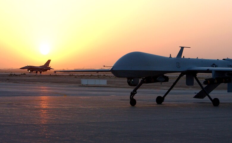 An MQ-1 Predator unmanned aerial vehicle and F-16 Fighting Falcon return from an Operation Iraqi Freedom combat mission. Both aircraft provide intelligence, search and reconnaissance gathering features, as well as munitions capability to support ground troops and base defense. (U.S. Air Force photo/1st Lt. Shannon Collins)              