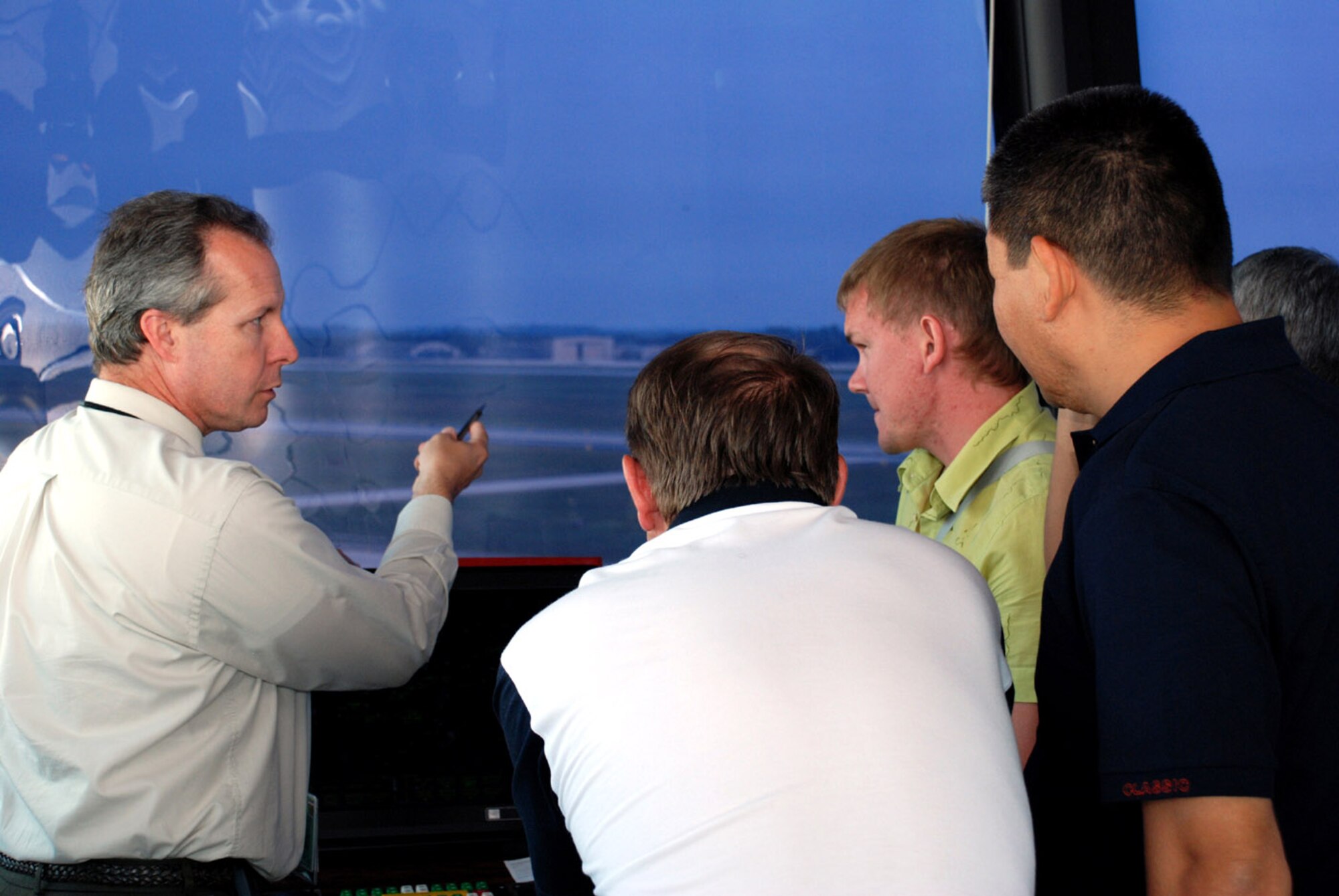 David Maddox explains the layout of the airfield to Igor Kulik, Taalaibek Alisherov, and Lev Semenovykh Sept. 6 at Andrews Air Force Base, Md. Mr. Maddox is the Federal Aviation Administration shift manager responsible for tower operations at Andrews AFB. The Kyrgyz air traffic controllers visited Andrews AFB and several other facilities in Virginia and Mississippi as part of a two-week orientation sponsored by U.S. Central Air Forces. The trip is part of an ongoing education and exchange program between Kyrgyz air navigation and the 376th Expeditionary Operations Support Squadron at Manas Air Base, Kyrgyzstan. The two organizations work closely together because the base is collocated with Manas International Airport. (U.S. Air Force photo/Senior Airman Alexy Saltekoff)
