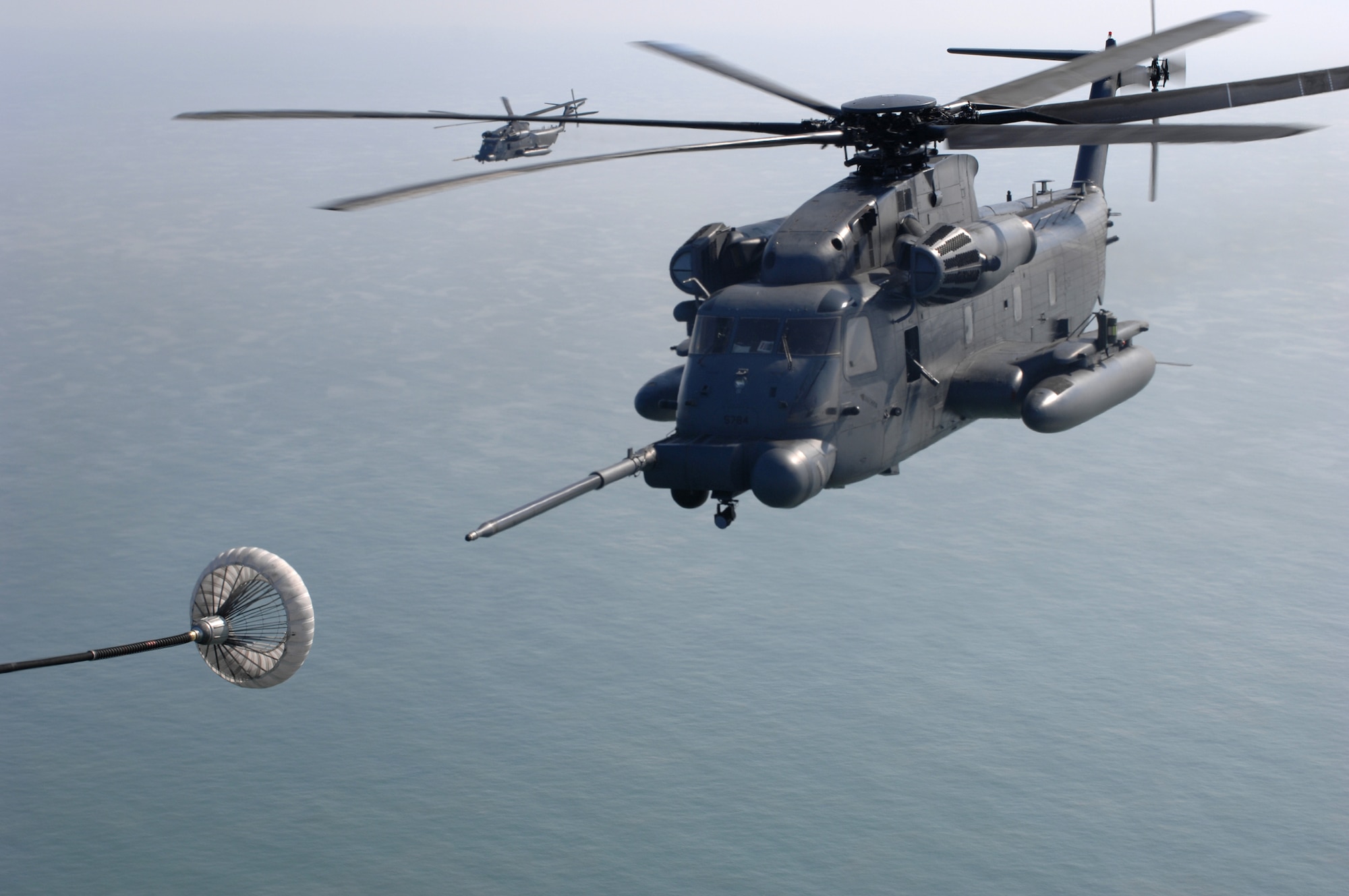Loadmaster, Staff Sgt. Marty Cowan, from the 67th Special Operations Squadron, flying in an MC-130P Combat Shadow, watches all five MH-53M Pave Low IV helicopters, from the 21st Special Operations Squadron stationed at RAF Mildenhall, England, line up for aerial refueling during their final flight, Sept. 13, 2007. The helicopters officially drop off the "operations books" as of Oct. 1, 2007.
(U.S. Air Force Photo by Tech. Sgt. Tracy L. DeMarco)
