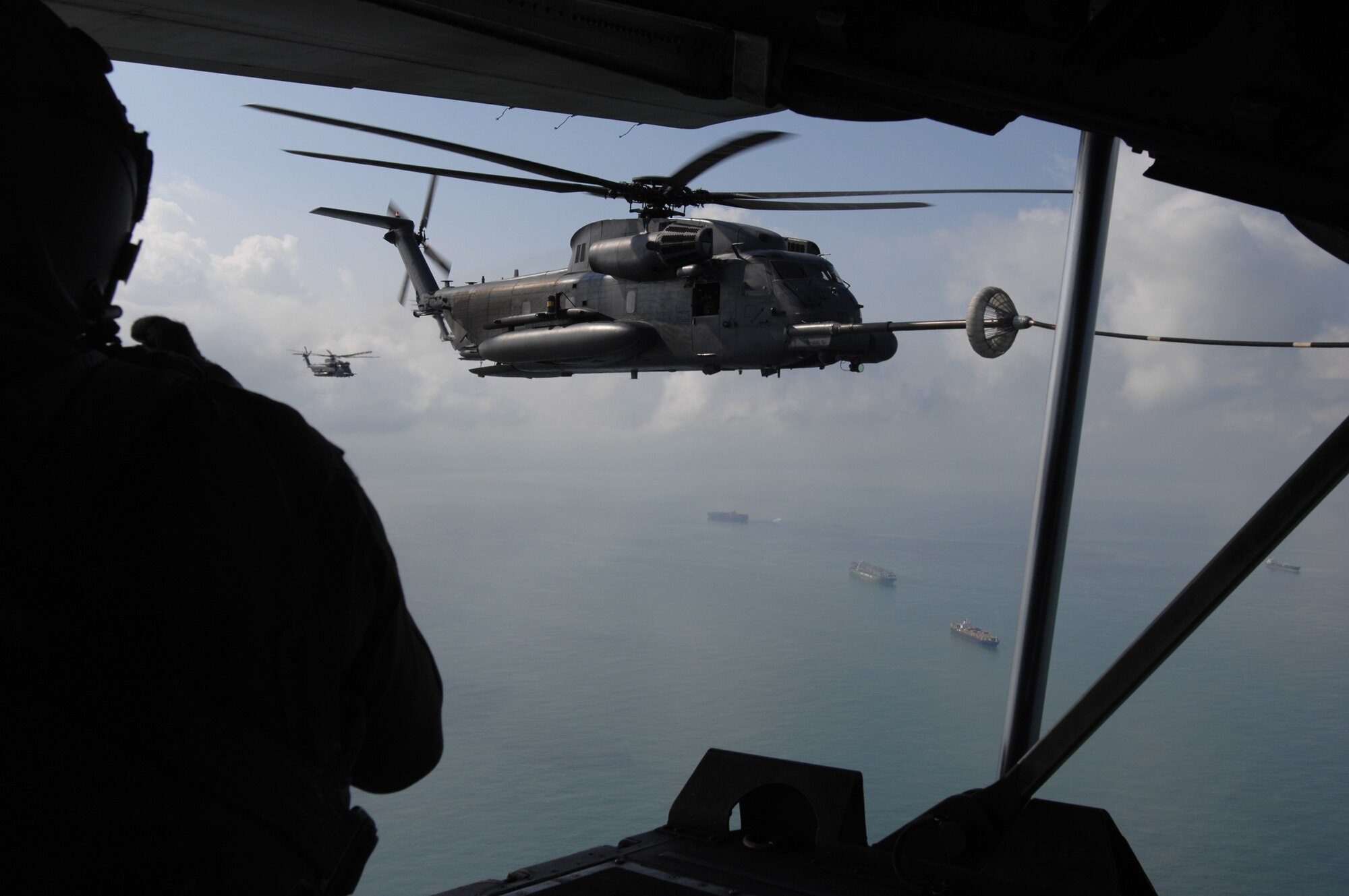 With tankers plowing through the ocean below and 67th Special Operations Squadron loadmaster, Staff Sgt. Marty Cowan looking on, one of the MH-53M Pave Low IV helicopters, from the 21st Special Operations Squadron stationed at RAF Mildenhall, receives fuel during the Pave Low's final flight, Sept. 13, 2007. The helicopters officially drop off the "operations books" as of Oct. 1, 2007.
(U.S. Air Force Photo by Tech. Sgt. Tracy L. DeMarco)
