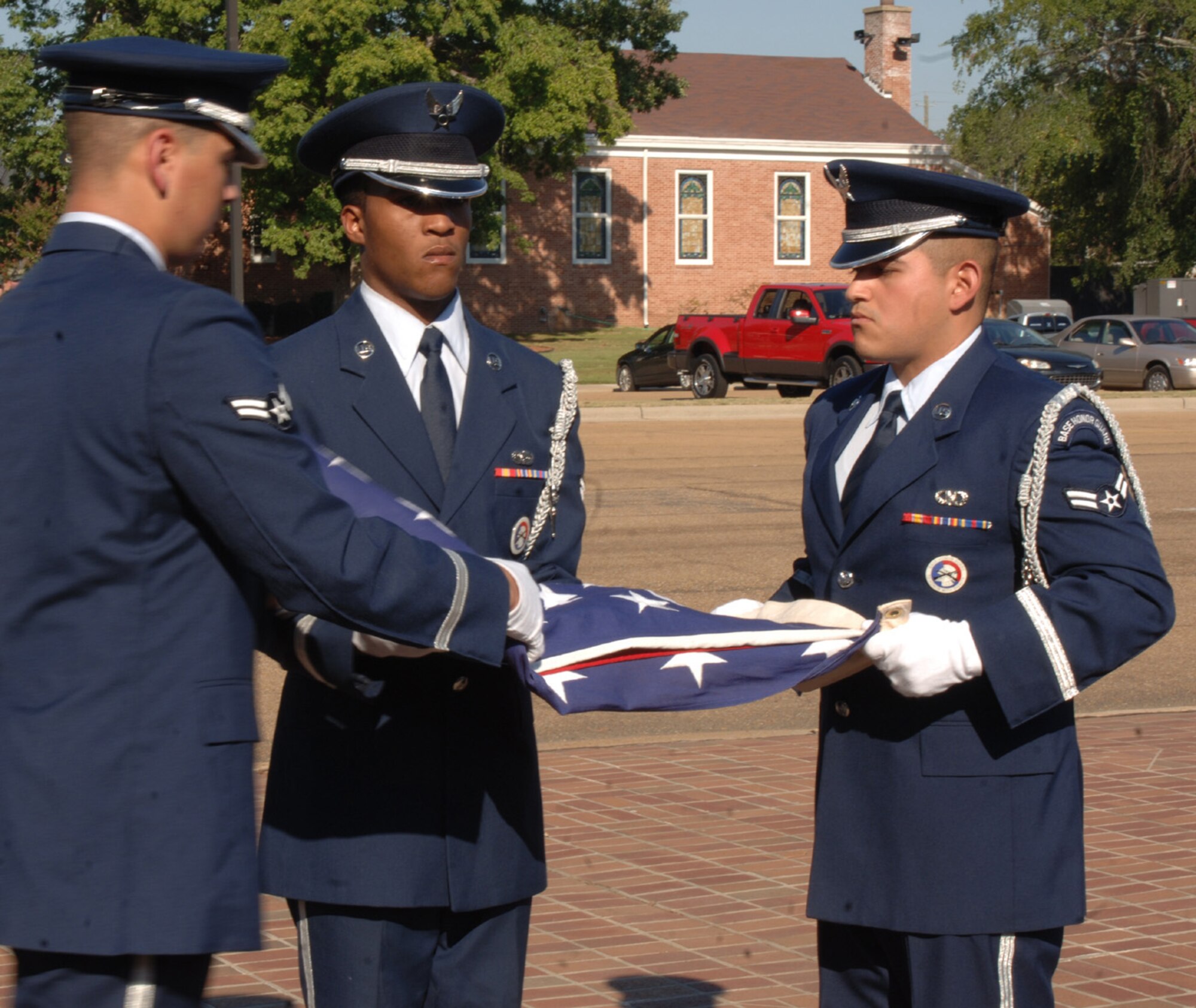 Honor Guard members Airman 1st Class Thomas Leguin, Airman LaQuan Conic and Airman 1st Class Matthew D'Arcangelo fold the American Flag during the POW/MIA Retreat ceremony Wednesday.  (U.S. Air Force photo by Airman 1st Class Danielle Powell)
