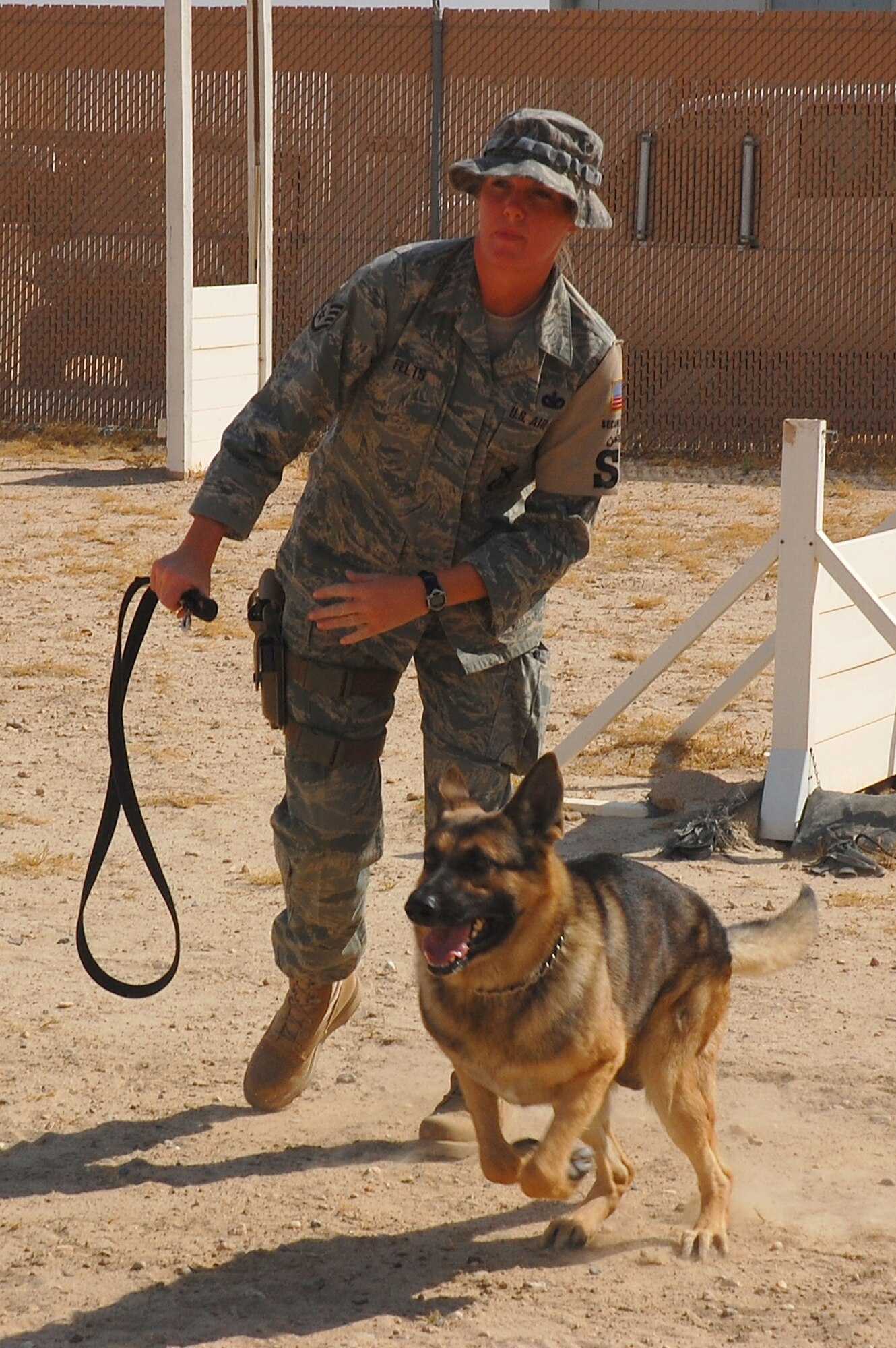 Staff Sgt. Laura Felts, 386th Expeditionary Security Forces Squadron military working dog handler, releases her partner, Bert, 386th ESFS military working dog, to attack a decoy during aggression training Sept 19, here. The military working dogs are trained several times a week to keep their skills sharp.   (U.S. Air Force photo by Staff Sgt. Tia Schroeder)
