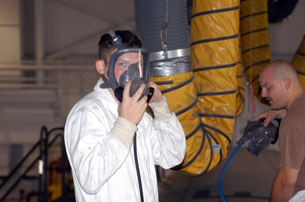 TSgt. Derek Reynolds, 911th Airlift Wing, maintenance squadron, dons his air mask in preparation for entering the #3 dry cell of a C-130 Hercules. (AF photo by Senior Airman Marc Nickens)                                 