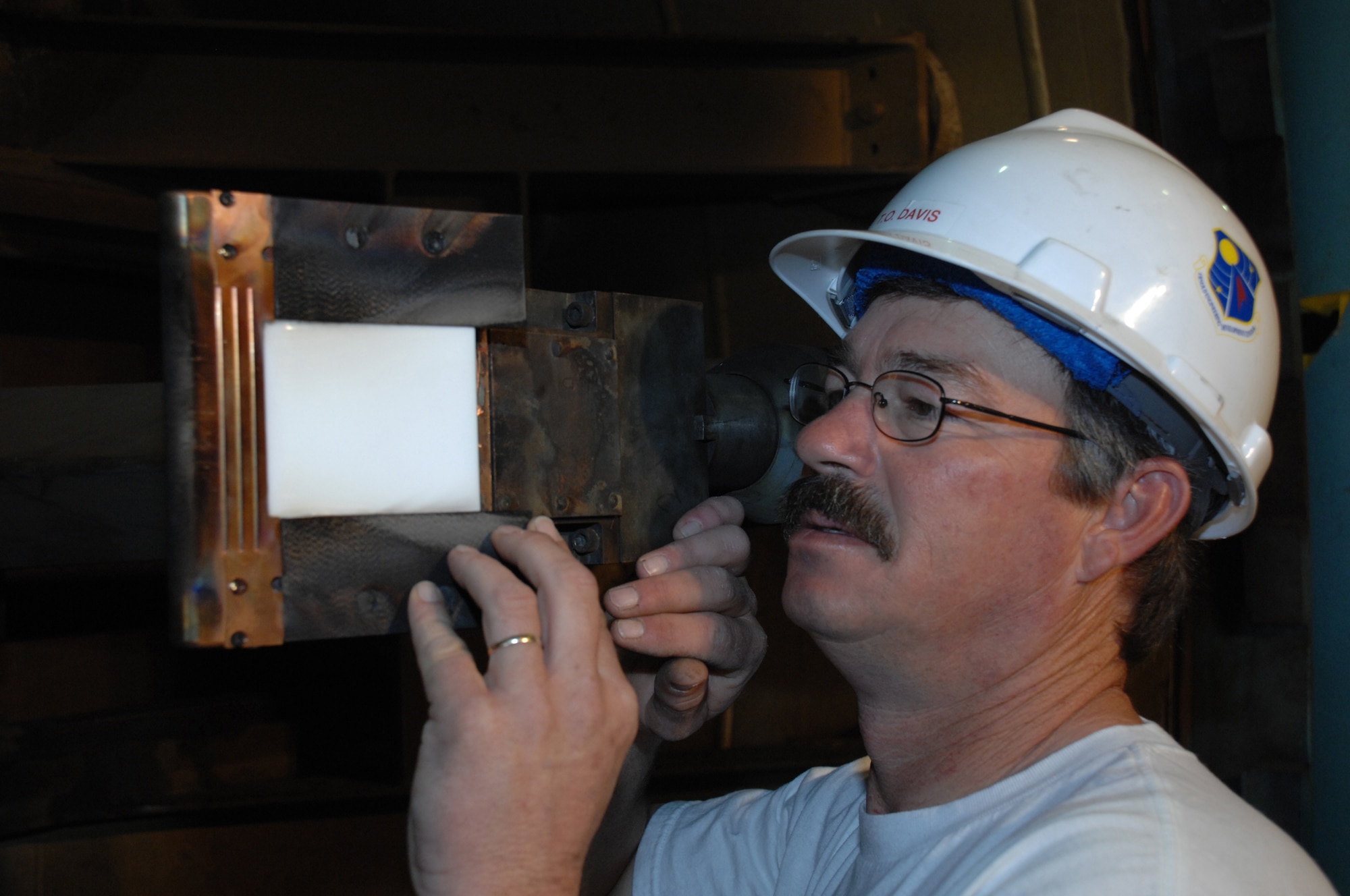 Troy Davis, Aerospace Testing Alliance outside machinist, checks the alignment of the Orion heat shield material sample prior to testing in H2. (Photo by Rick Goodfriend)