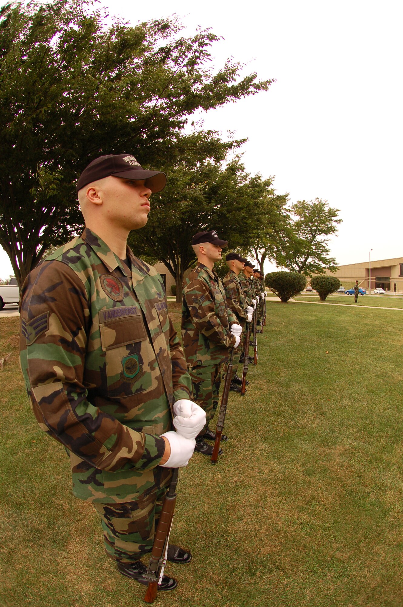 Team Dover honor guard members stand ready, rifles at feet, awaiting orders. The honor guard fired a 21-gun salute at the ceremony. (U.S. Air Force photo/Tech. Sgt. Kevin Wallace)