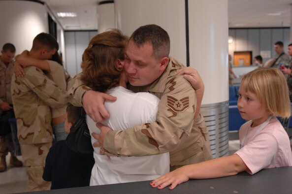 A 100th Civil Engineer Squadron firefighter , Staff Sgt. Michael Wilson, hugs his wife Shanna before boarding a plane that will take him to his deployed location, Sept. 14, 2007. Sergeant Wilson also said goodbye to his 9-year-old daughter Emily and son Peyton, 7. (U.S. Air Force photo by Tech. Sgt. Tracy L. DeMarco)
