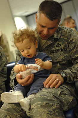 While waiting for his flight, Master Sgt. Michael Lang, a 100th Operations Support Squadron Airman, holds his 16-month-old son Nathaniel at the RAF Mildenhall passenger terminal, Sept. 14, 2007. This will be Sergeant Lang's third deployment but only his first as a father. The plane was an hour late arriving that morning giving Sergeant Lang time to help Nathaniel eat his cereal.  (U.S. Air Force photo by Tech. Sgt. Tracy L. DeMarco)

