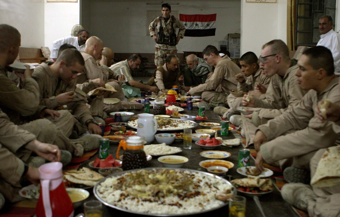 070927-M-1876J-SHEIKS02— Company L’s commanding officer, Capt. Quintin D. Jones with 3rd Battalion, 3rd Marine Regiment with Regimental Combat Team 6, and his Marines sit down to an Iraqi feast a sheik offered to them as a gift of generosity, Sept. 22. Jones visits with sheiks in Karmah, Iraq, as part of tribal engagement efforts to ensure community security and boost economic growth.