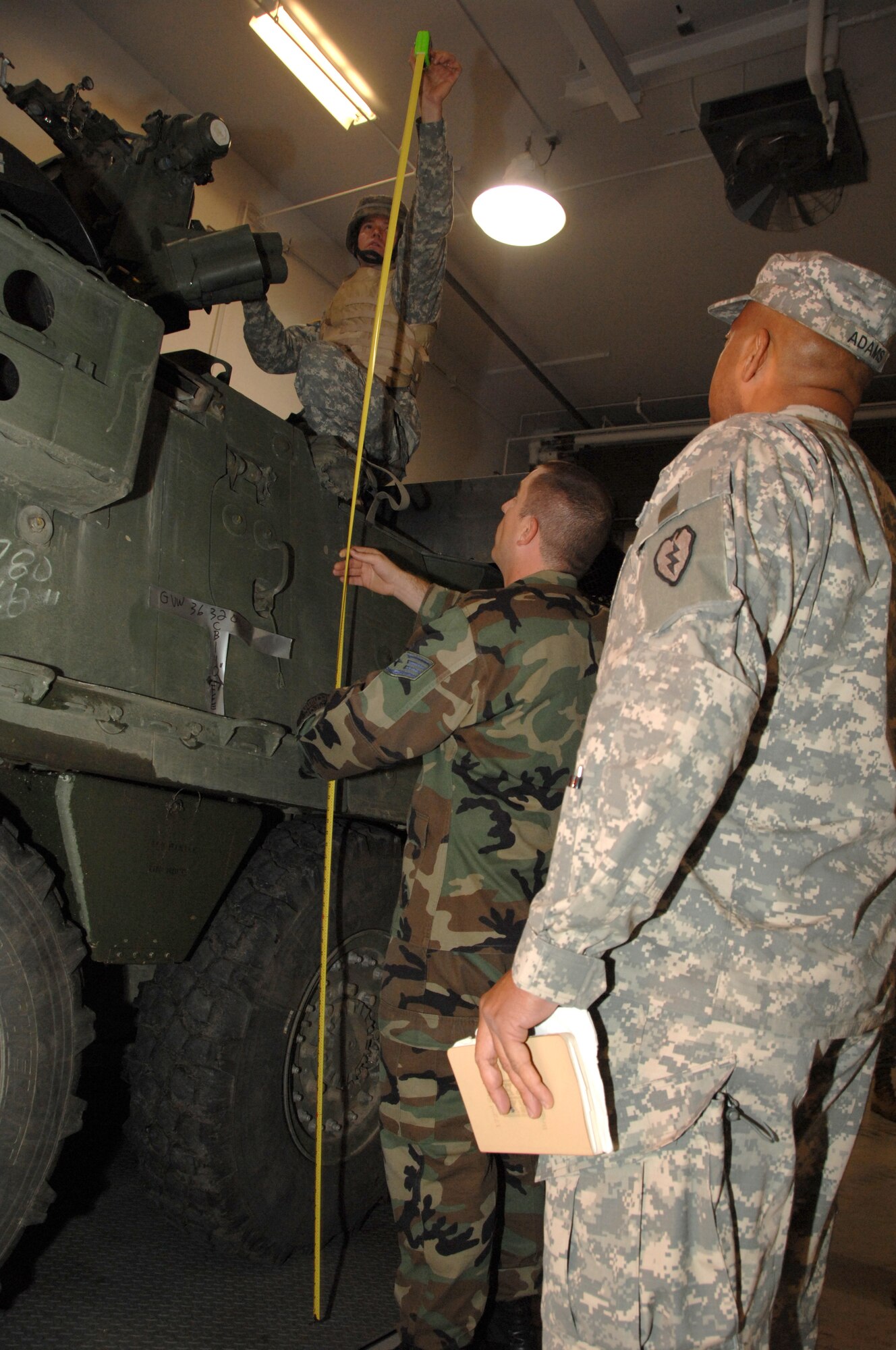 EIELSON AIR FORCE BASE, Alaska -- Staff Sgt. Brad DeVinney, 354th Logistic Readiness Squadron, and soldiers of the 1/25 Stryker Brigade Team, work together to find the dimensions of a Stryker Combat Vehicle Sept. 19, 2007 at the ammunition processing facility adjacent to the Eielson Joint Mobility Complex. Eielson's 354th Logistic Readiness Squadron personnel conducted a joint training event to orientate Stryker personnel on aerial movement preparation of the Stryker Combat Vehicle. This was the first time Icemen and Arctic Wolves teamed up to conduct joint mobility training featuring Eielson as an aerial port of embarkation.  (U.S. Air Force photo by Airman 1st Class Christopher Griffin)