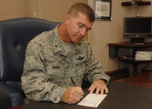 Brig. Gen. Mark Barrett, 1st Fighter Wing commander, signs his Combined Federal Campaign form to kick off Langley's CFC efforts. Langley's campaign runs from Sept. 21 to Nov. 2. People who wish to donate can contact their unit CFC representative. (U.S. Air Force photo/Staff Sgt. Katrina Shellman)
