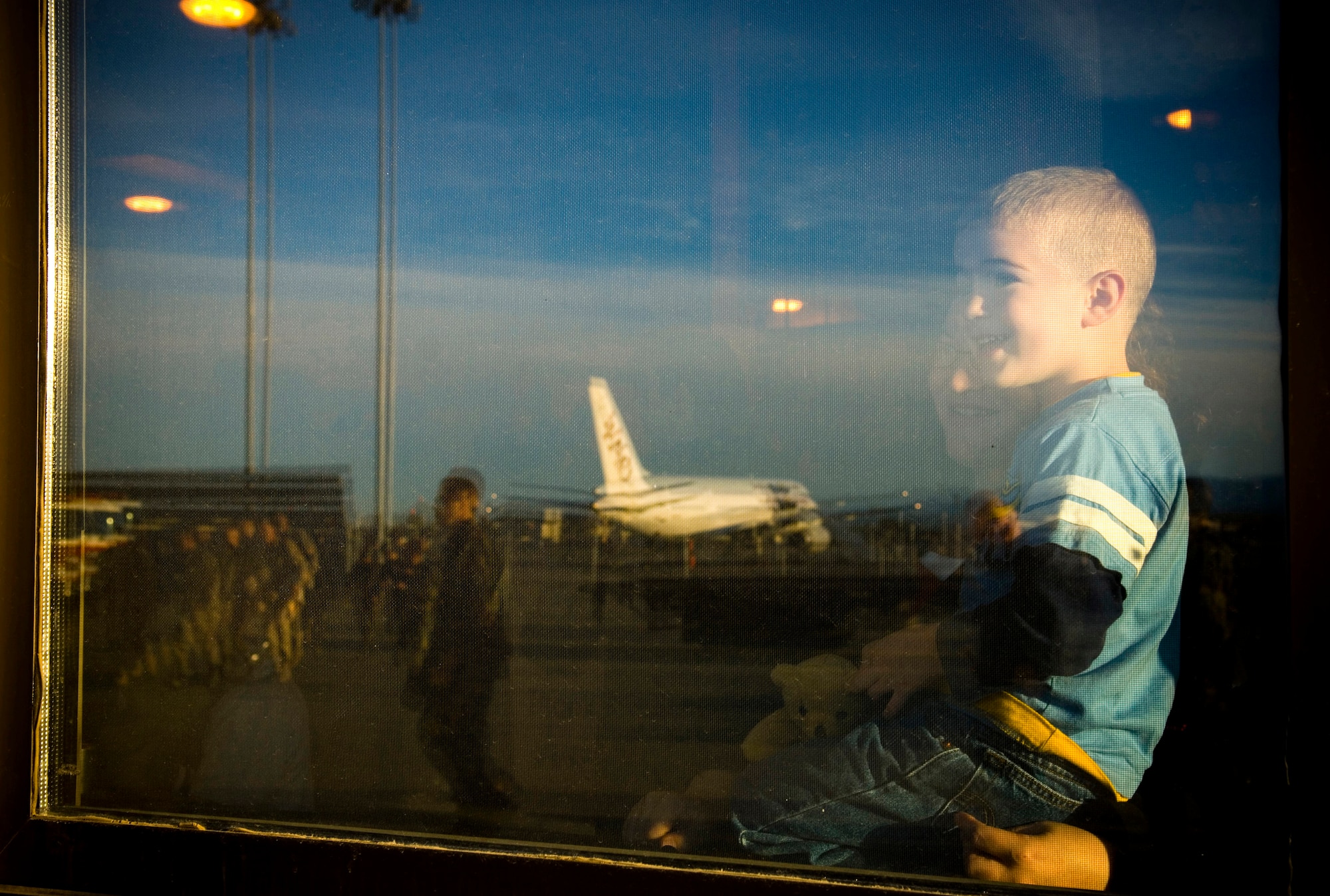Garrison Veith, held in the arms of his mother, Jessica Veith, smiles after spotting his father among 40 other Airmen returning home to their friends and families from their deployed locations Sept. 17 to Elmendorf Air Force Base, Alaska. The Airmen returned to loved ones awaiting their arival at the joint military complex. (U.S. Air Force photo/Senior Airman Garrett Hothan)
