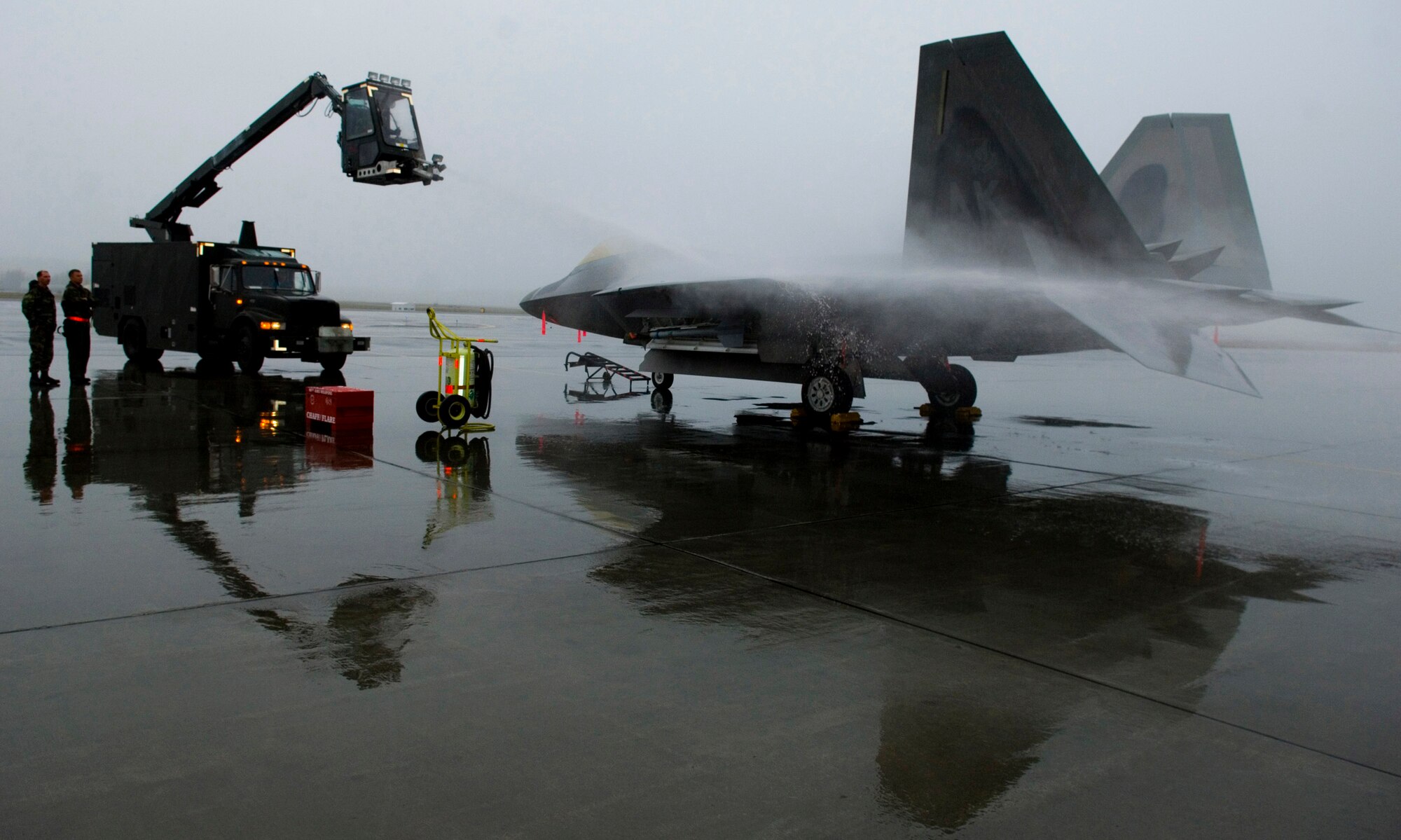 Maintainers at Elmendorf Air Force Base, Alaska, practice de-icing an F-22 Raptor Sept. 19 to prepare for the upcoming winter.  The onset of light dustings of snow on the surrounding mountain ranges is a sign the Alaskan winter is just around the corner. (U.S. Air Force photo/Senior Airman Garrett Hothan)