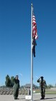 (Left) Col. Scott Dennis, 388th Fighter Wing commander, and (right) Chief Master Sgt. Wayne Brown from the 388th Aircraft Maintenance Squadron, raise the flag and salute during the POW/MIA Recognition Day ceremony Sept. 21.