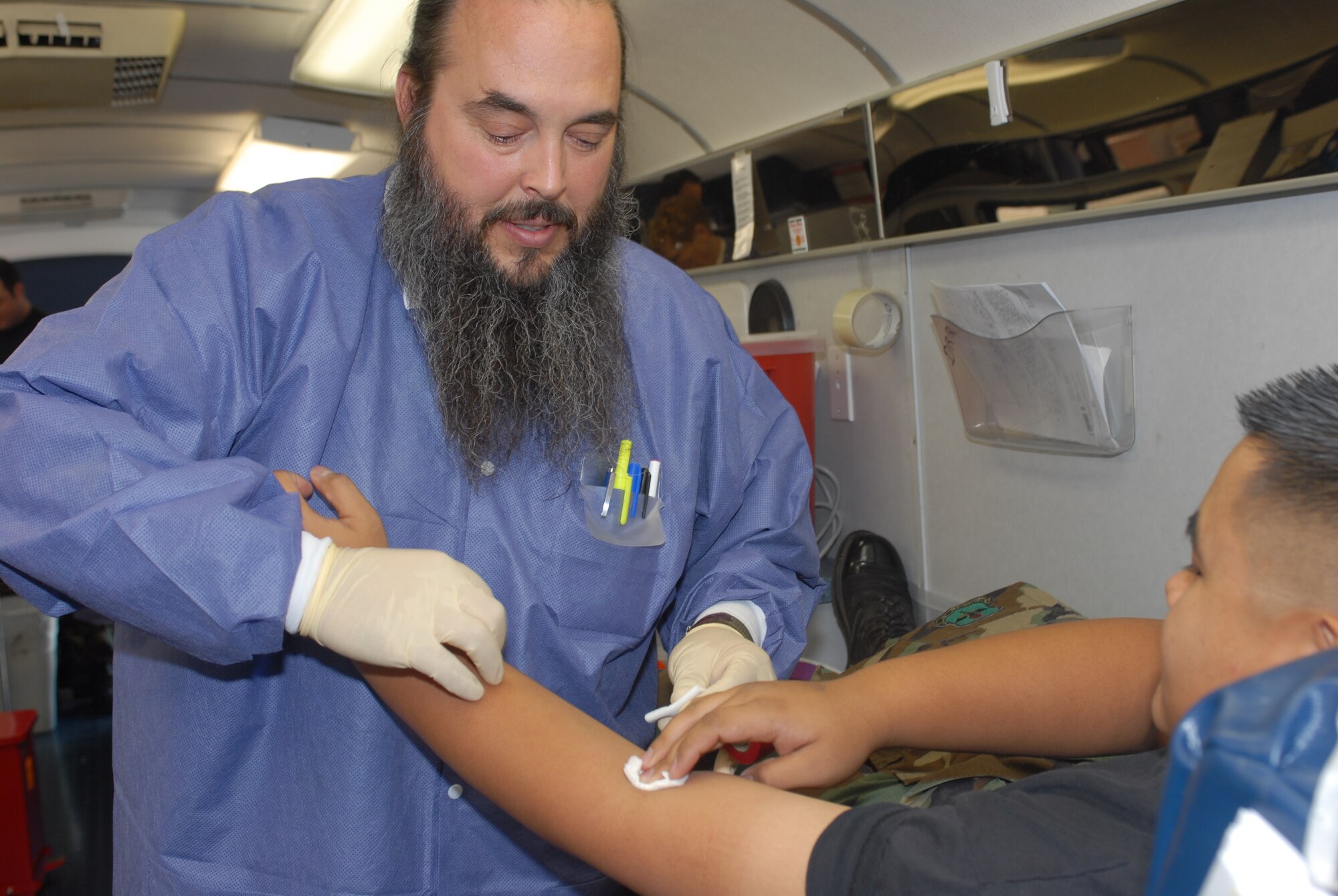 United Blood Services technician Mark Trujillo, draws blood from Senior Airman Johmil Eslao, 309th Aircraft Maintenance Unit, at the base blood drive Sept. 17.(photo by Airman 1st Class David Bulkley)