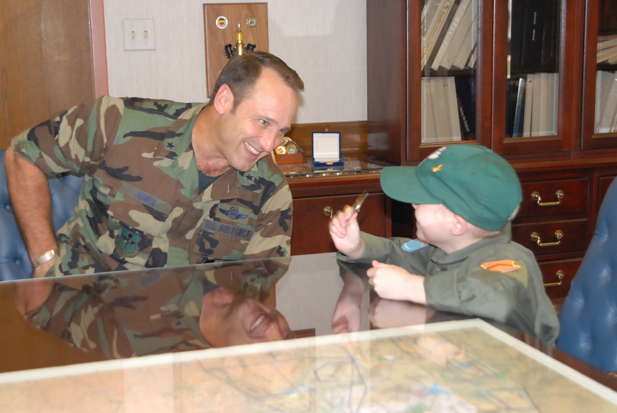 Brig. Gen Tom Jones, 56th Fighter Wing commander, jokes with 7-year-old Nick McCluen in the general's office Sept. 14. Nick enjoyed a full day of activities at
the 310th Fighter Squadron learning what it’s like to be an F-16 pilot and was coined by General Jones. (photo by 2nd Lt. Bryan Bouchard)