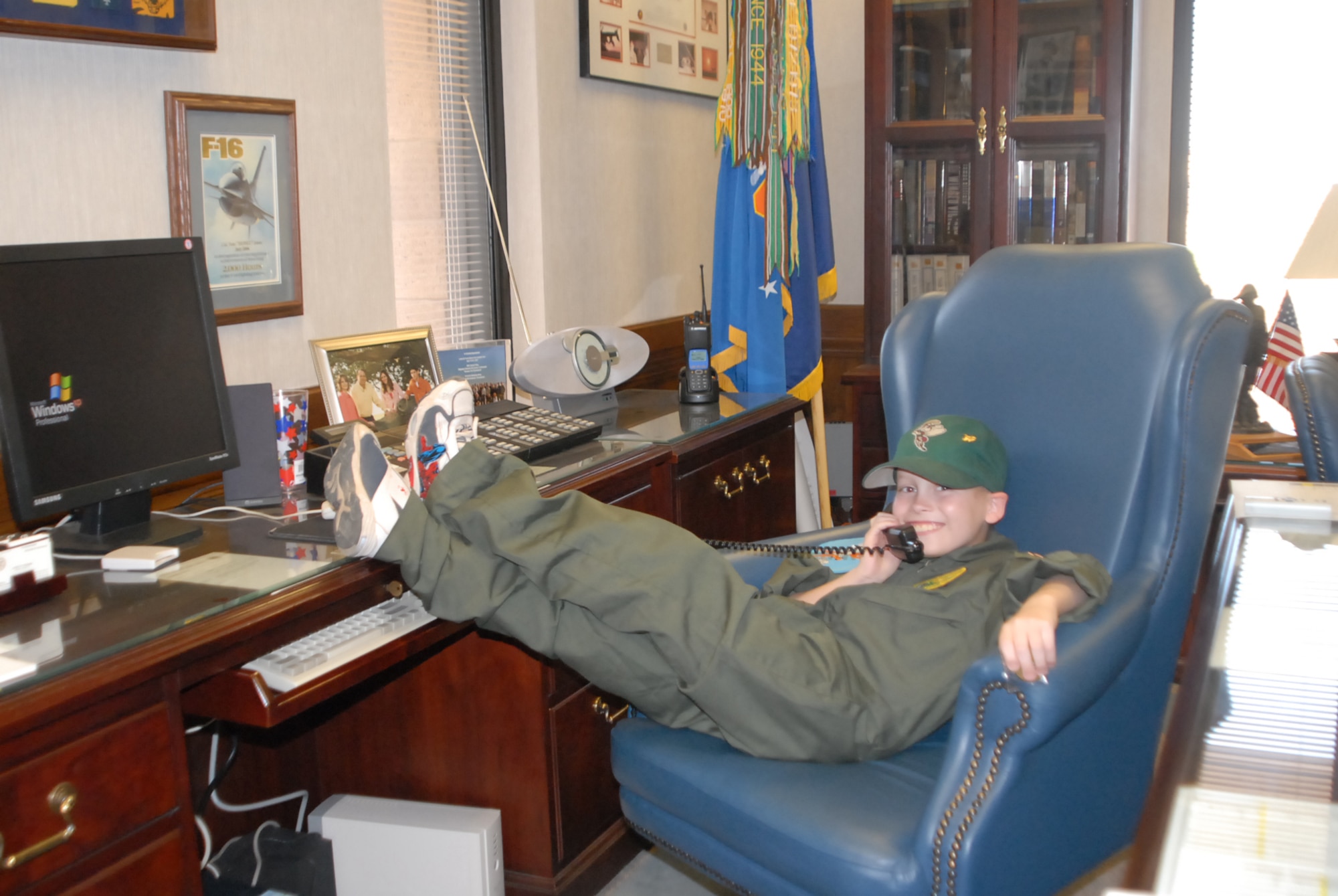 Pilot for a day, Nick McCluen, 7, relaxes in the office of Brig. Gen. Tom Jones, 56th Fighter Wing commander, when he visited Luke Sept. 14. Nick enjoyed a full day of activities at the 310th Fighter Squadron learning what it’s like to be an F-16 pilot. (photo by 2nd Lt. Bryan Bouchard)