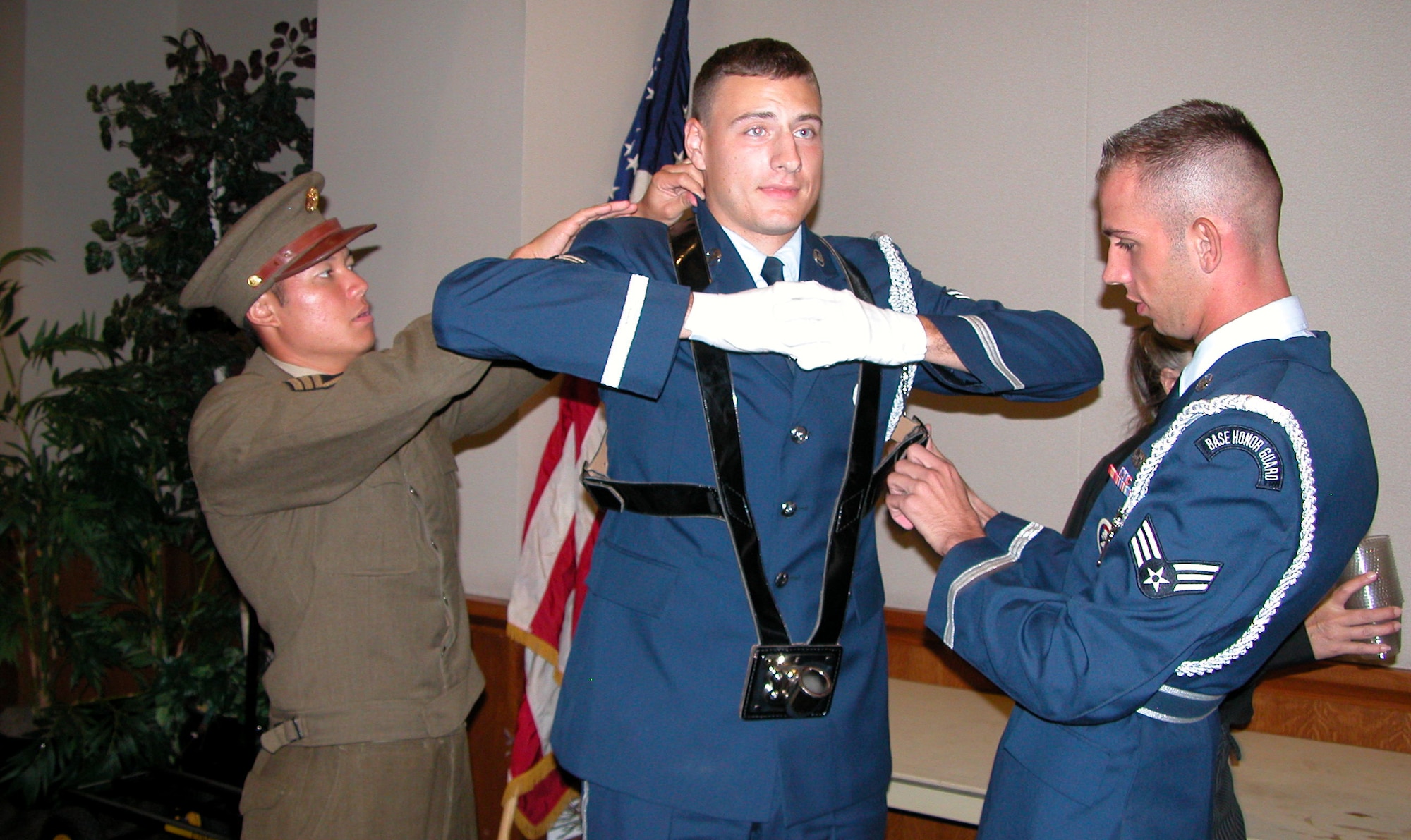 From left, Senior Airman Isaiah Hiapo, Airman 1st Class Walter Woods, and Senior Airman Richard Middlebrook prepare for the Pageant of Flags at the Air Force Ball
Sept. 15 at the Glendale Civic Center. Airman Hiapo was dressed in a heritage uniform. Uniforms from as far back as the American Revolution were worn by Airmen during the ball. More than 600 people attended the event commemorating the Air Force's 60th birthday. (Photo by Capt. Miki Gilloon)
