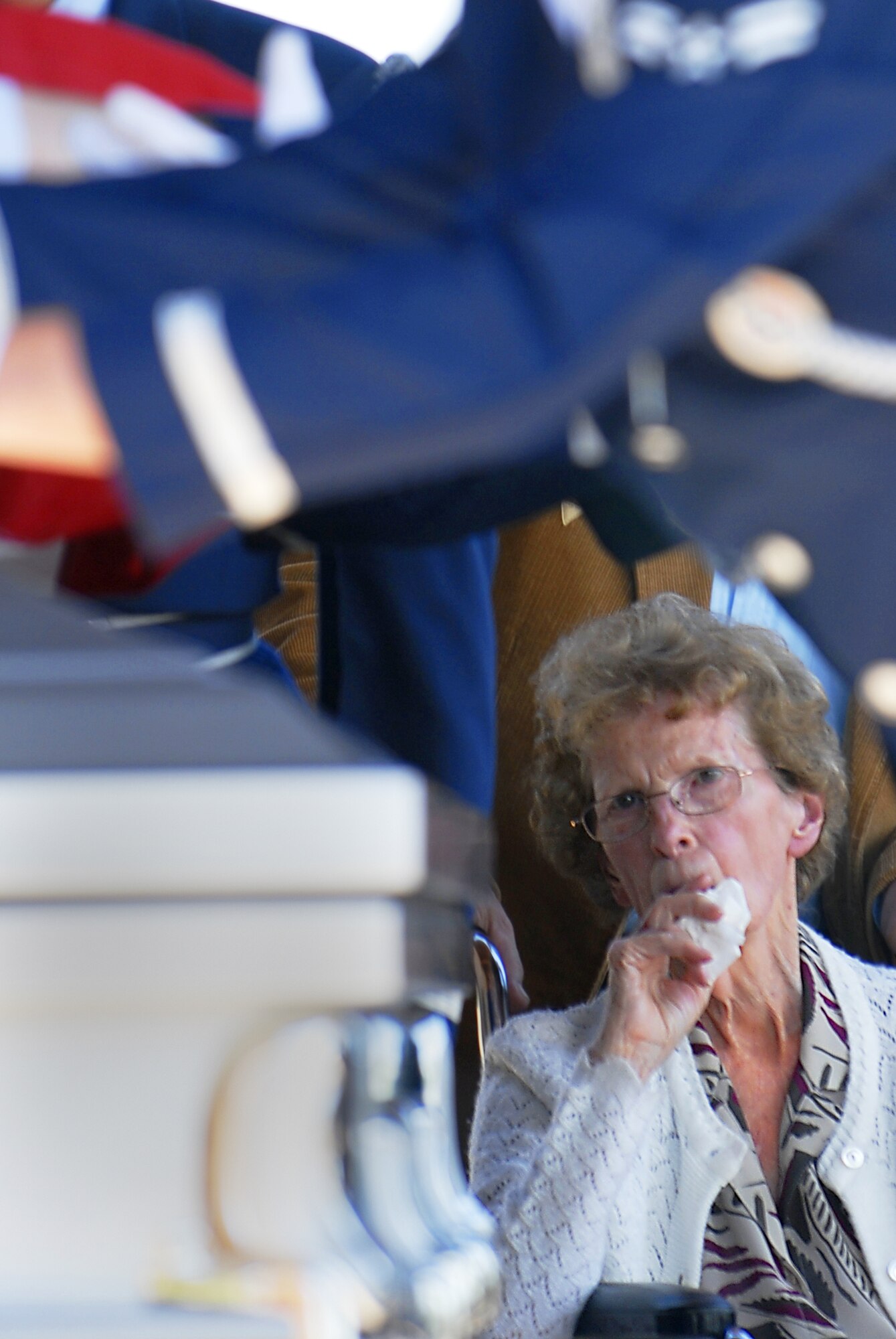 The Luke Honor Guard performs a flag folding over the casket of veteran Dean Haslam as his widow Paula, looks on. (photo by Senior Airman Christopher Hummel)