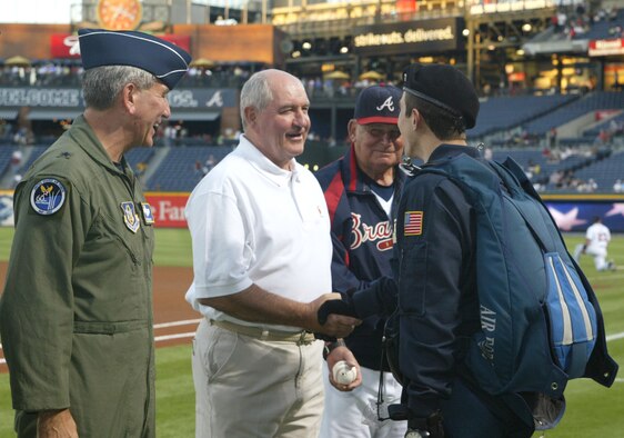 A parachutist from the Air Force Wings of Blue, Air Force Academy presents Brig. Gen. Ric Stevenson, Air Force Reserve vice commander, Georgia Governor Sonny Perdue and Bobby Cox, manager of the Atlanta Braves with a baseball that was flown around the world.