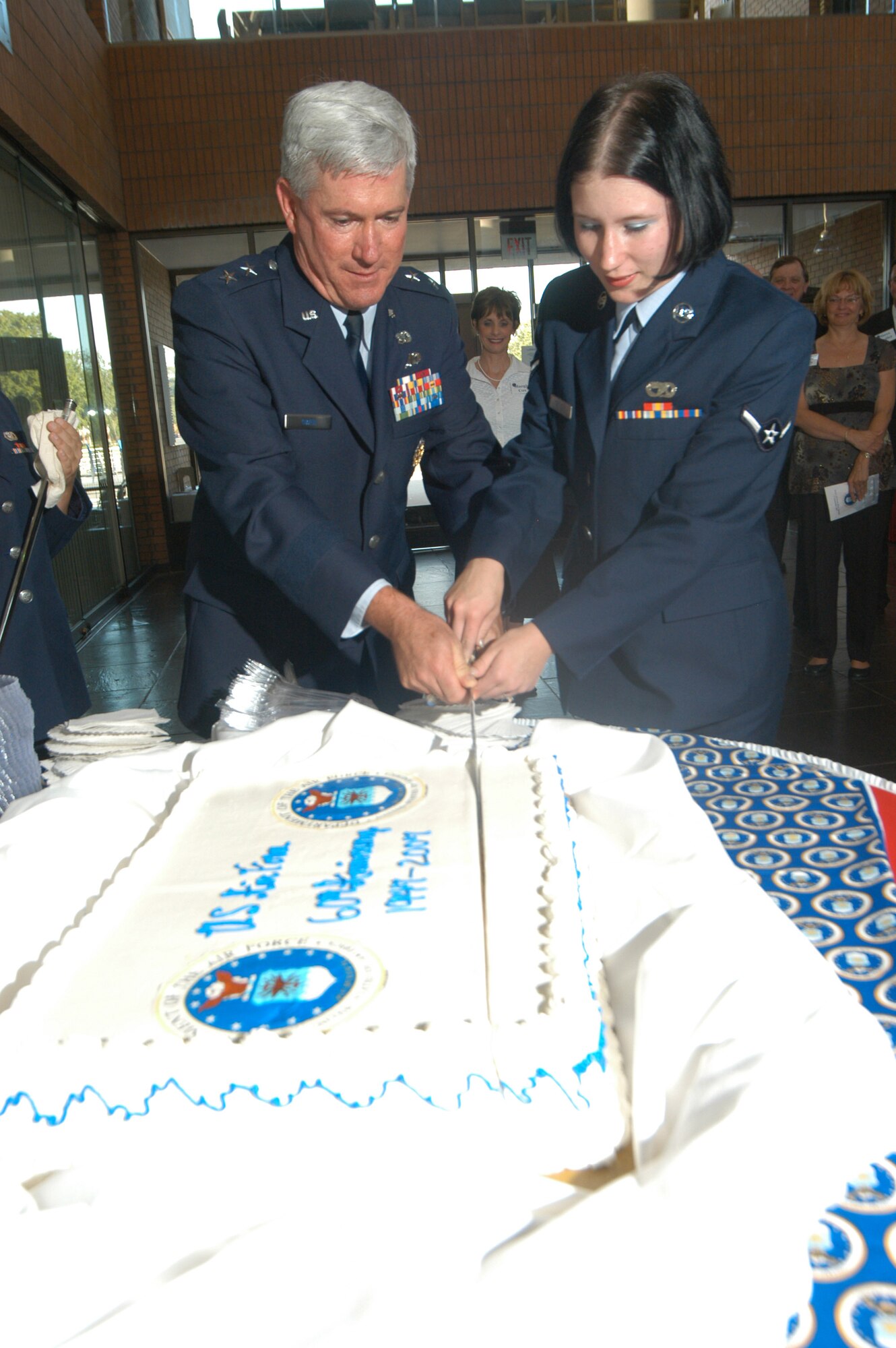 Maj. Gen. Tom Owen, Warner Robins Air Logistics Center commander, the most senior ranking member of the base, and Airman Savannah Taylor, the youngest Airman stationed at Robins, cut the Air Force’s 60th birthday cake with a sabre during the Air Force 60th Birthday reception Monday.    U.S. Air Force photo by Sue Sap