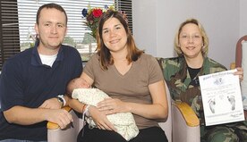 Tech. Sgt. Craig Clapper, 744th Communications Squadron Base Multimedia NCOIC sits next to his wife Heather and their newborn daughter Addison Olivia Clapper, as Col. Janet Deltuva, 79th Medical Group deputy commander, holds the birth certificate. Addison was the 240th baby born this year at Malcolm Grow Medical Center, born Sept. 3, weighing 9 pounds 5 ounces. (US Air Force/TSgt Jason Edwards)